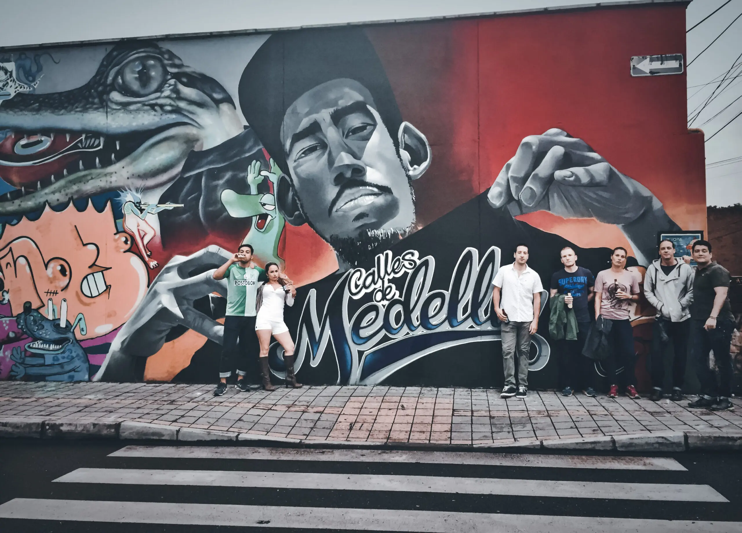 Street art mural with people posing in front.