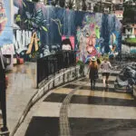 women walking down the street near grafitti-covered walls