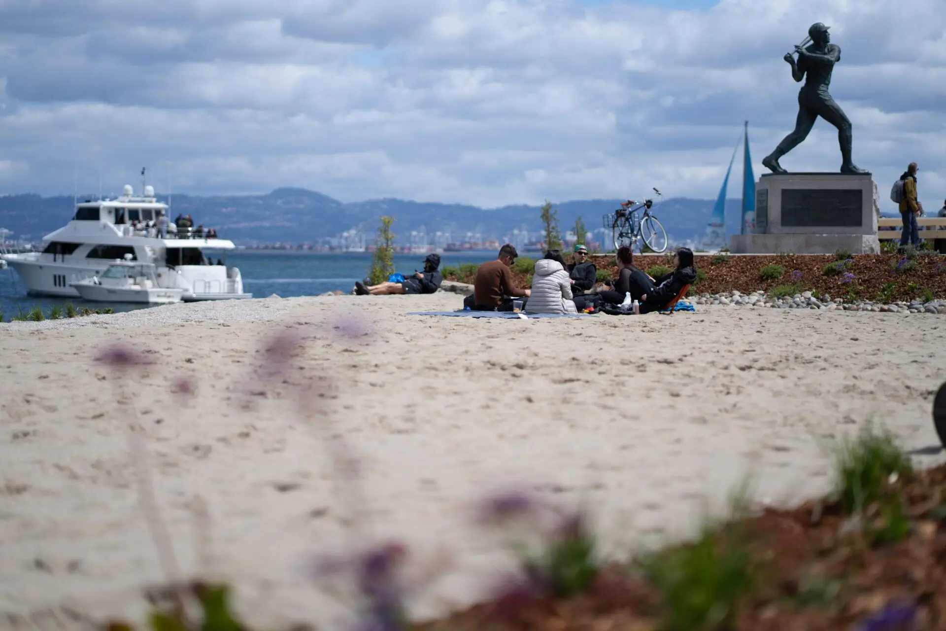 Group relaxing on the sand with views toward the Bay Bridge and downtown.