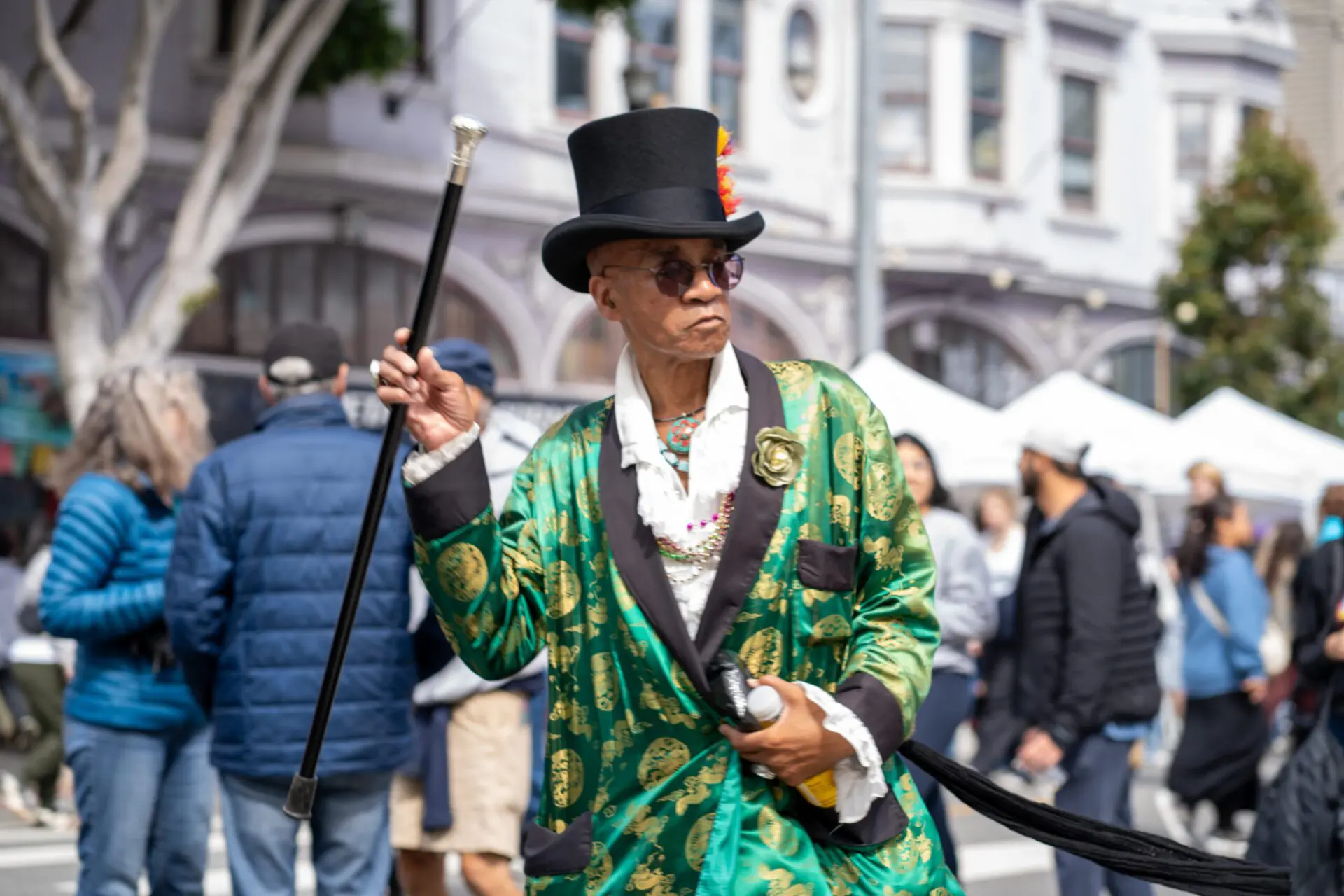 Man in green patterned coat and top hat holding a cane