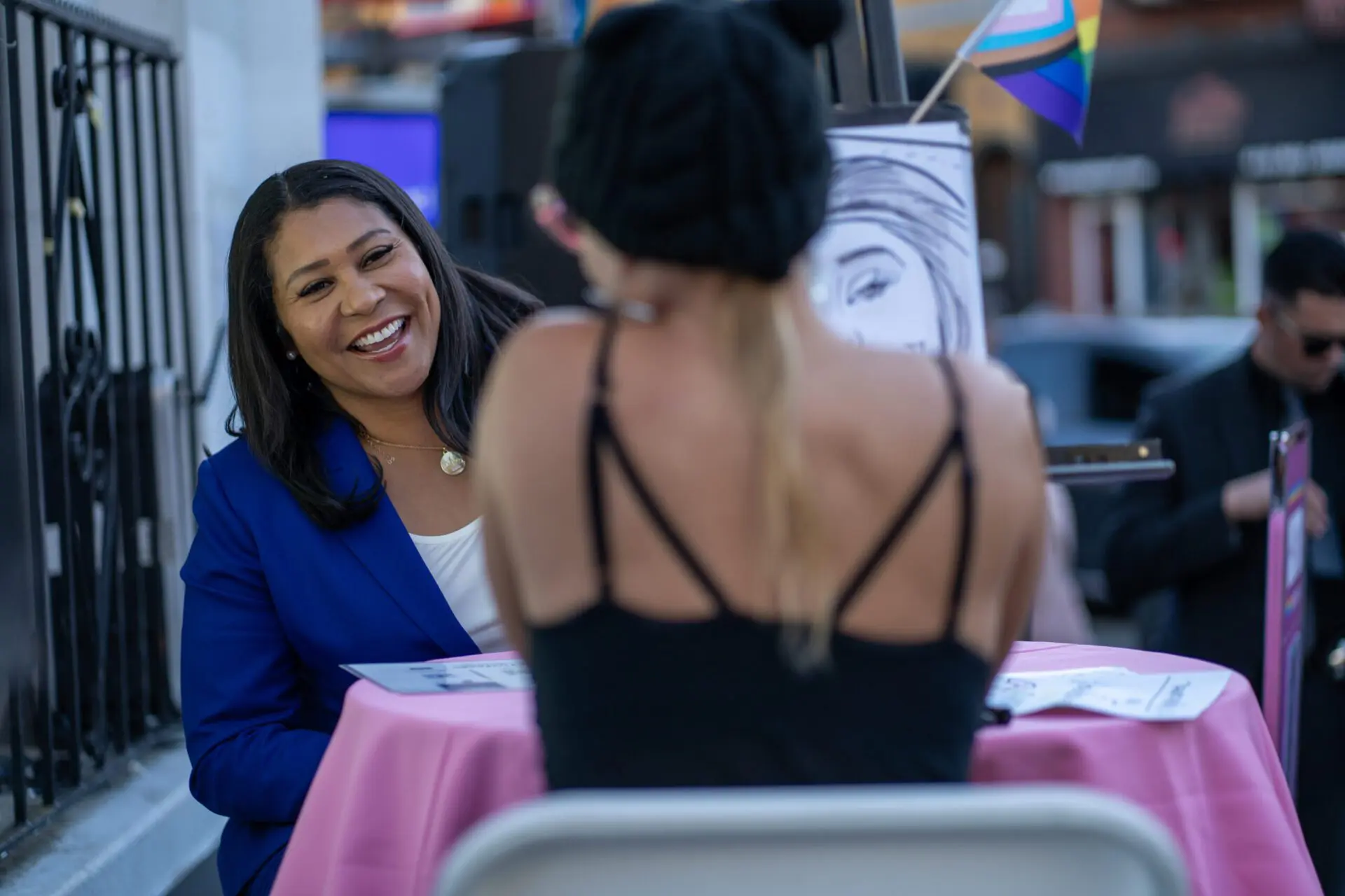 Two women laughing during a tarot or reading session at a pink table