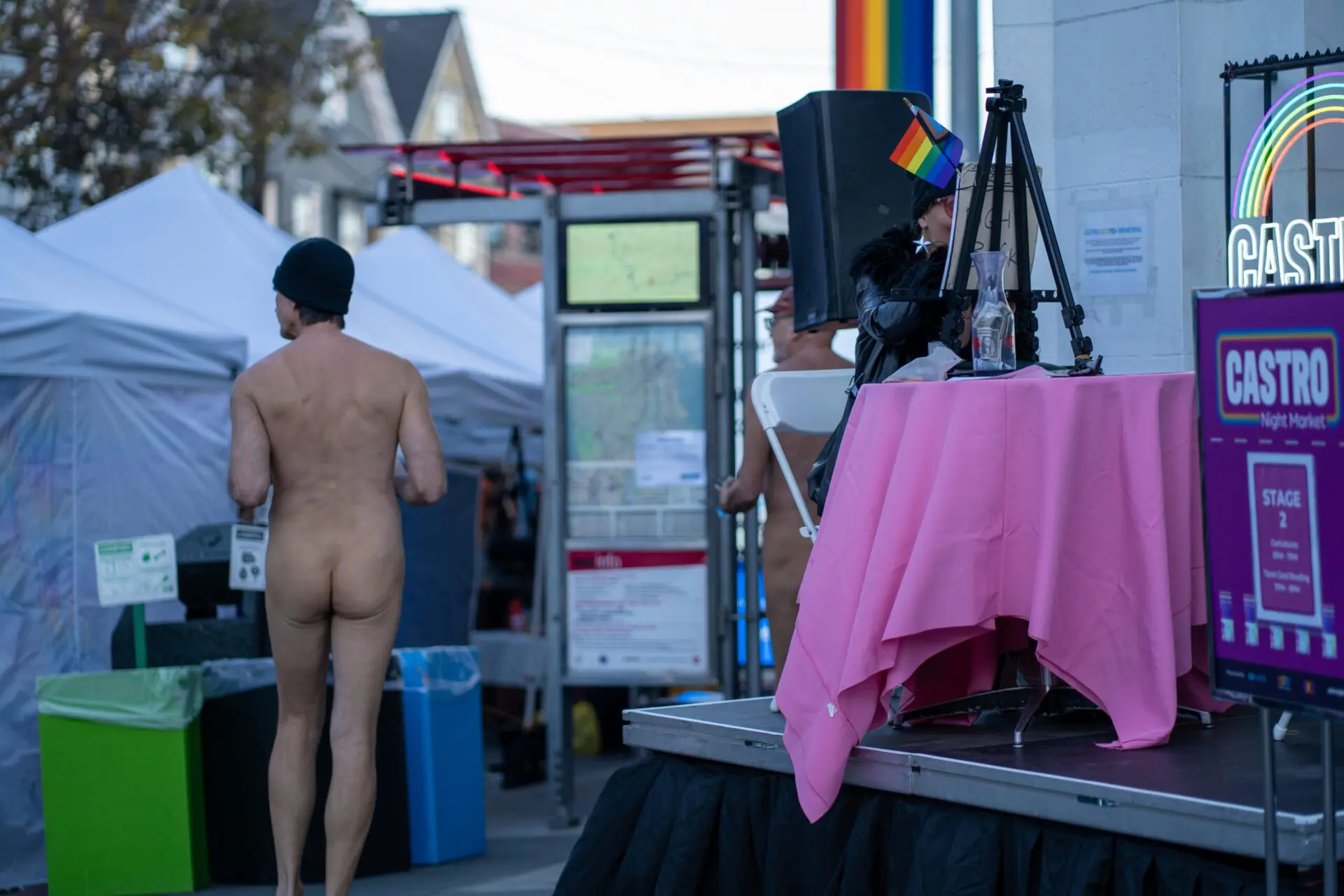 Performer onstage with a nude-costumed figure in the background