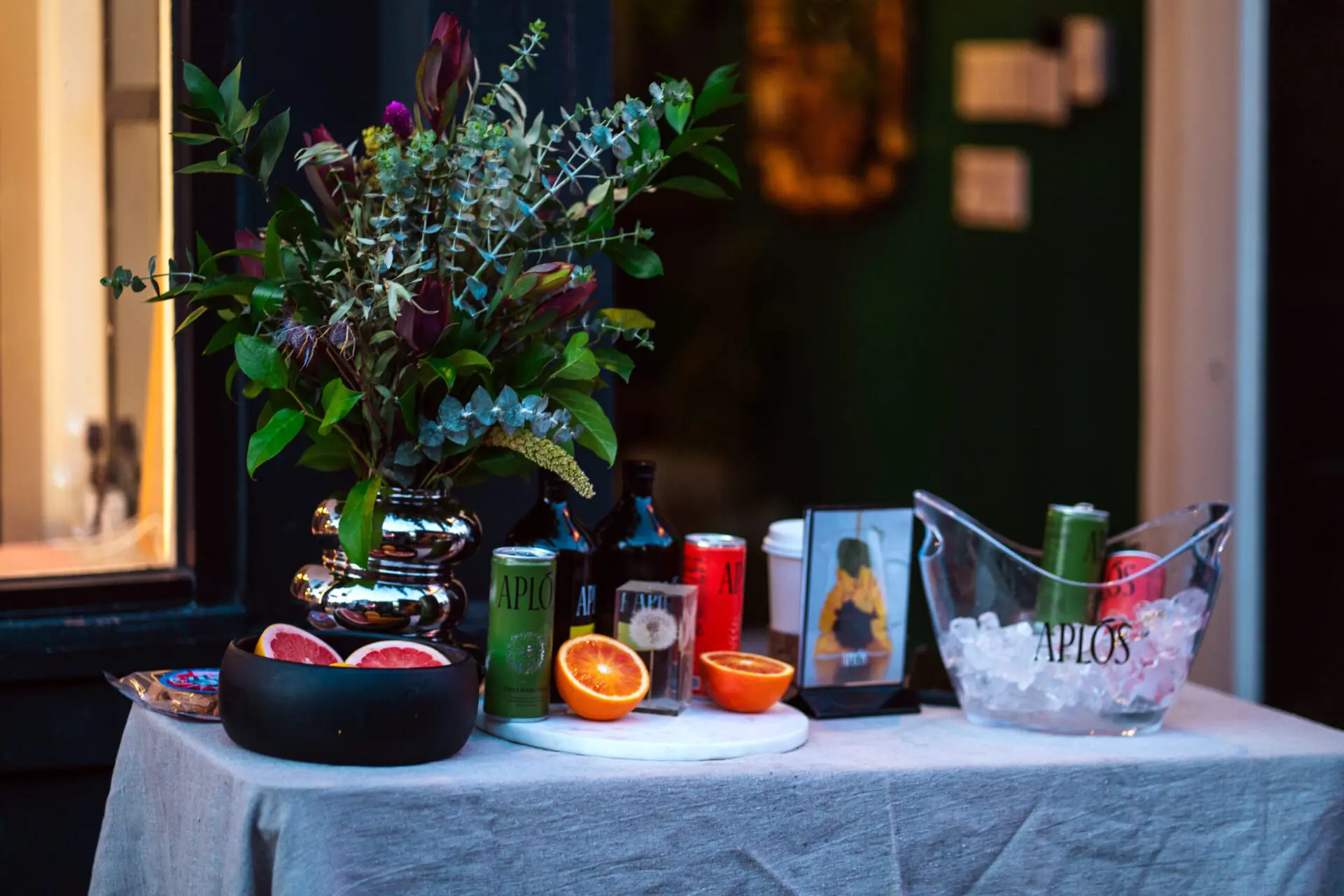 Table display with flowers, fruit, and drinks at a Castro storefront