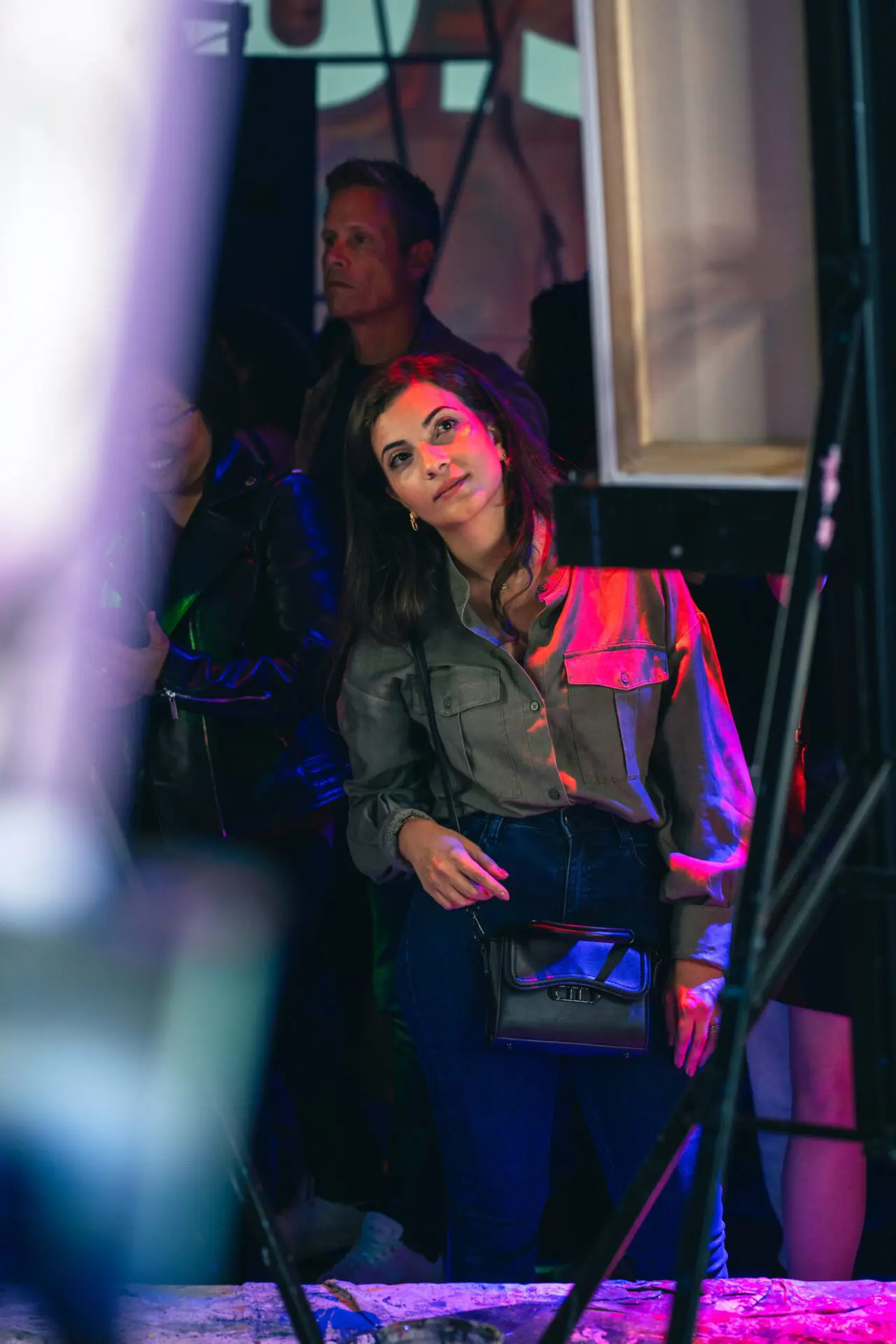 Woman sitting at her easel looking toward the stage lights.