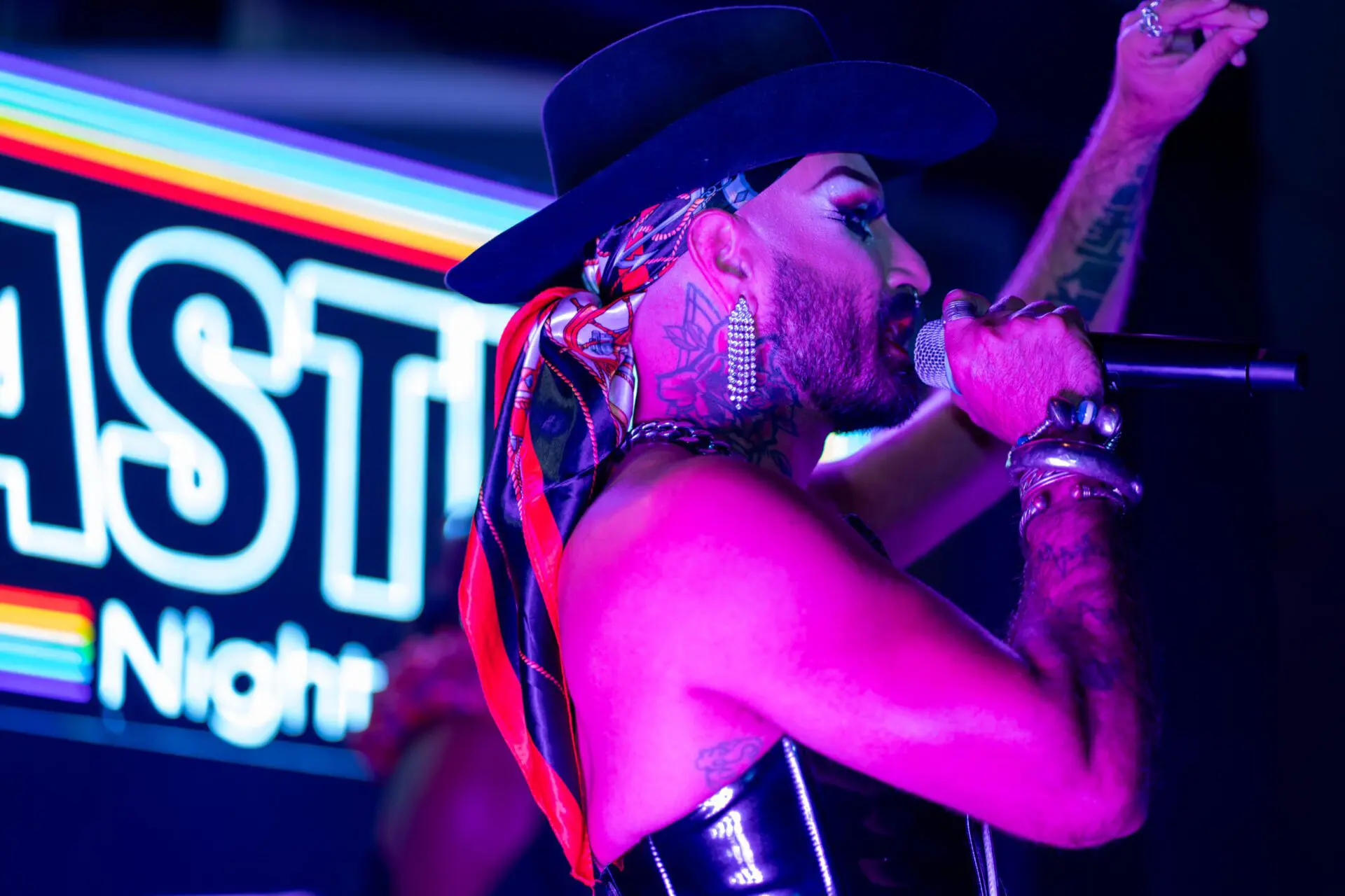 Drag performer posing under bright stage lights at Castro Night Market
