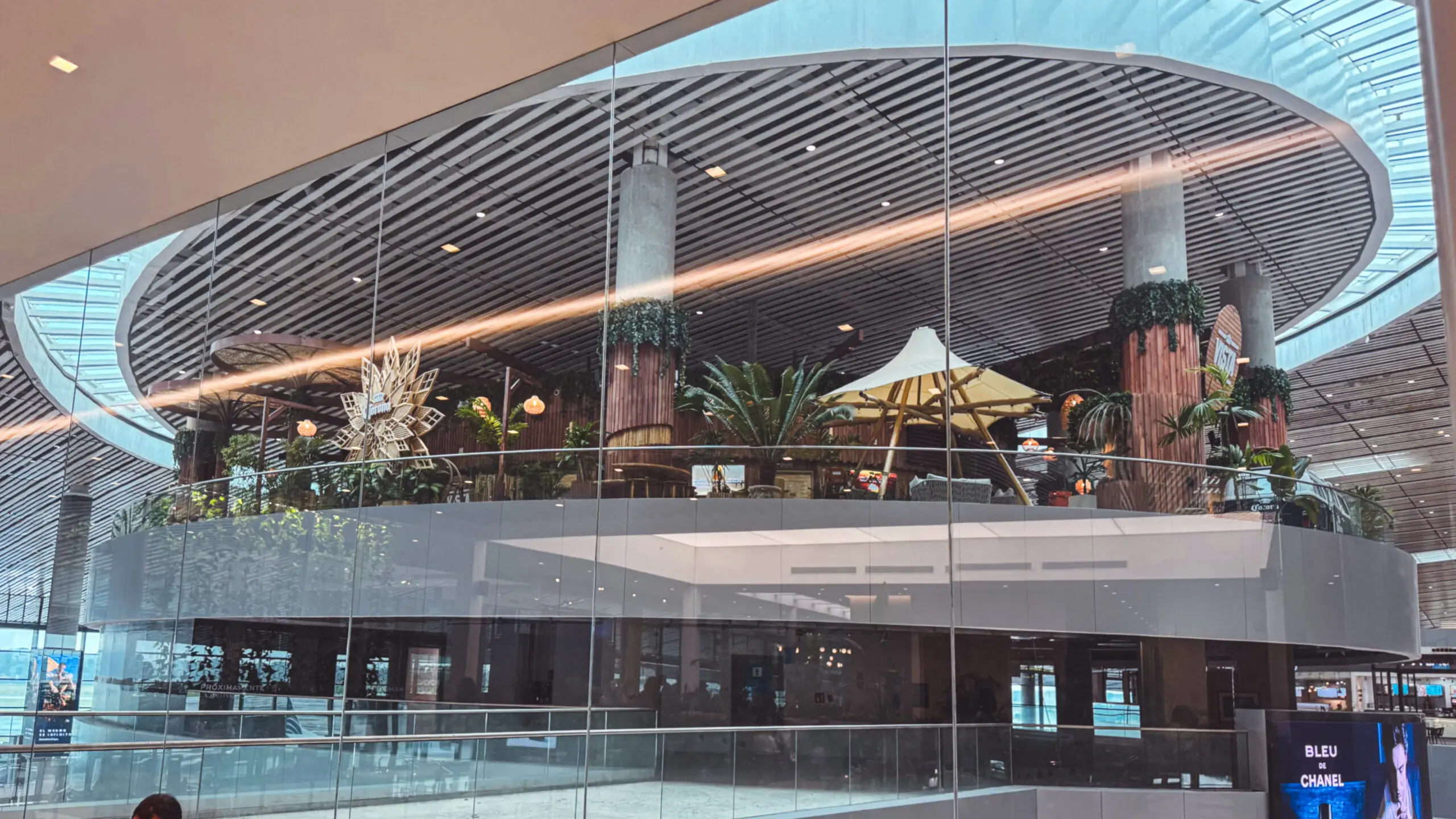 Panoramic view of the upper-level seating and greenery inside the Copacabana Airport Lounge.