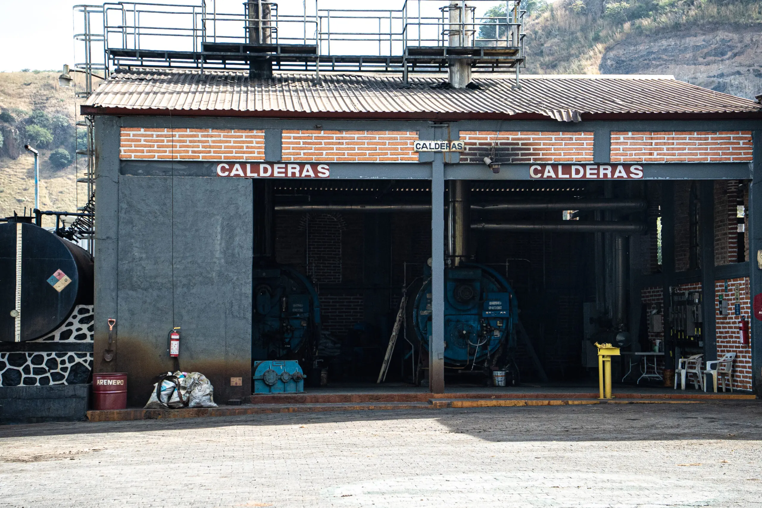 Old industrial boilers inside a weathered warehouse.