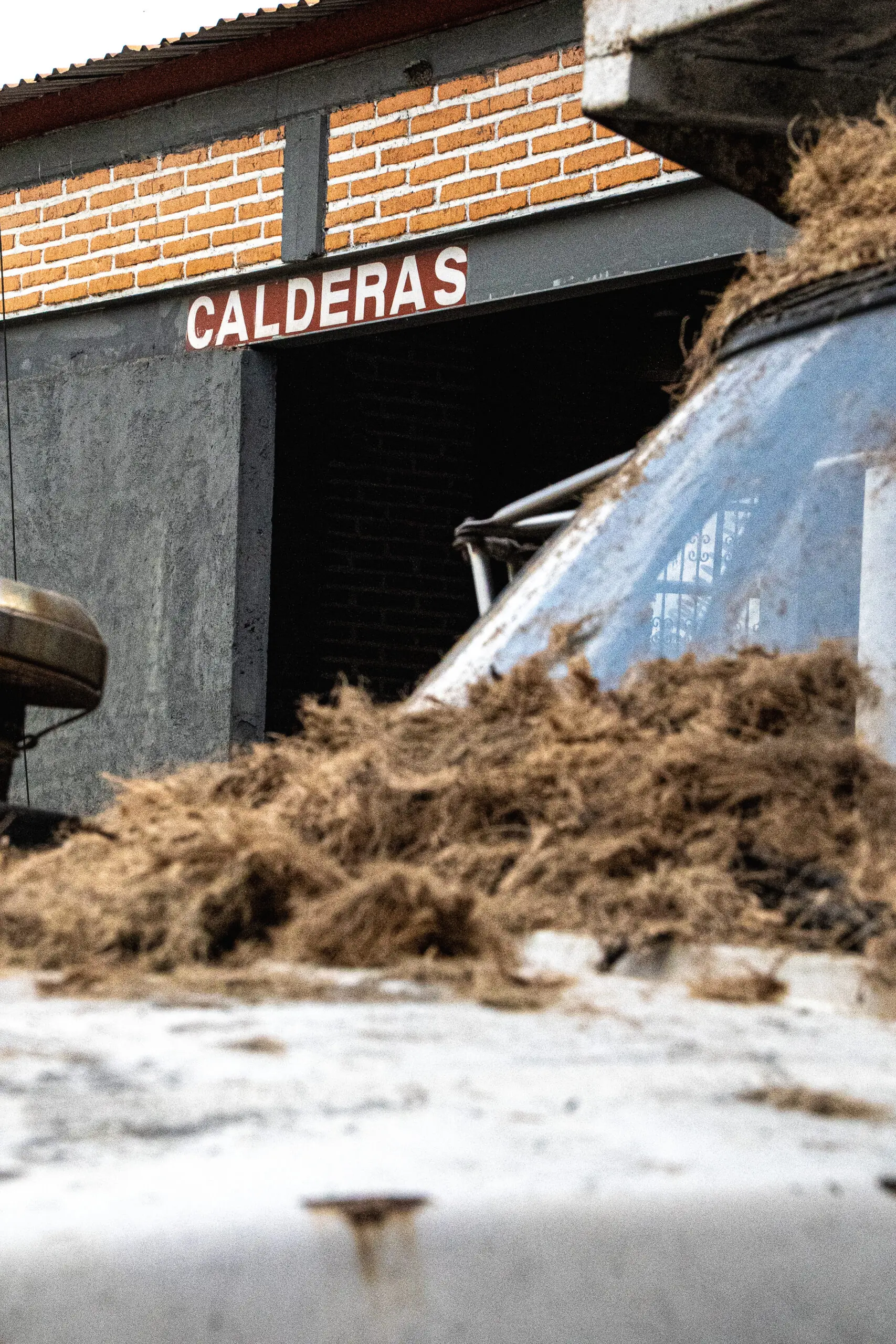 Piles of organic material outside a building labeled 'CALDERAS'.
