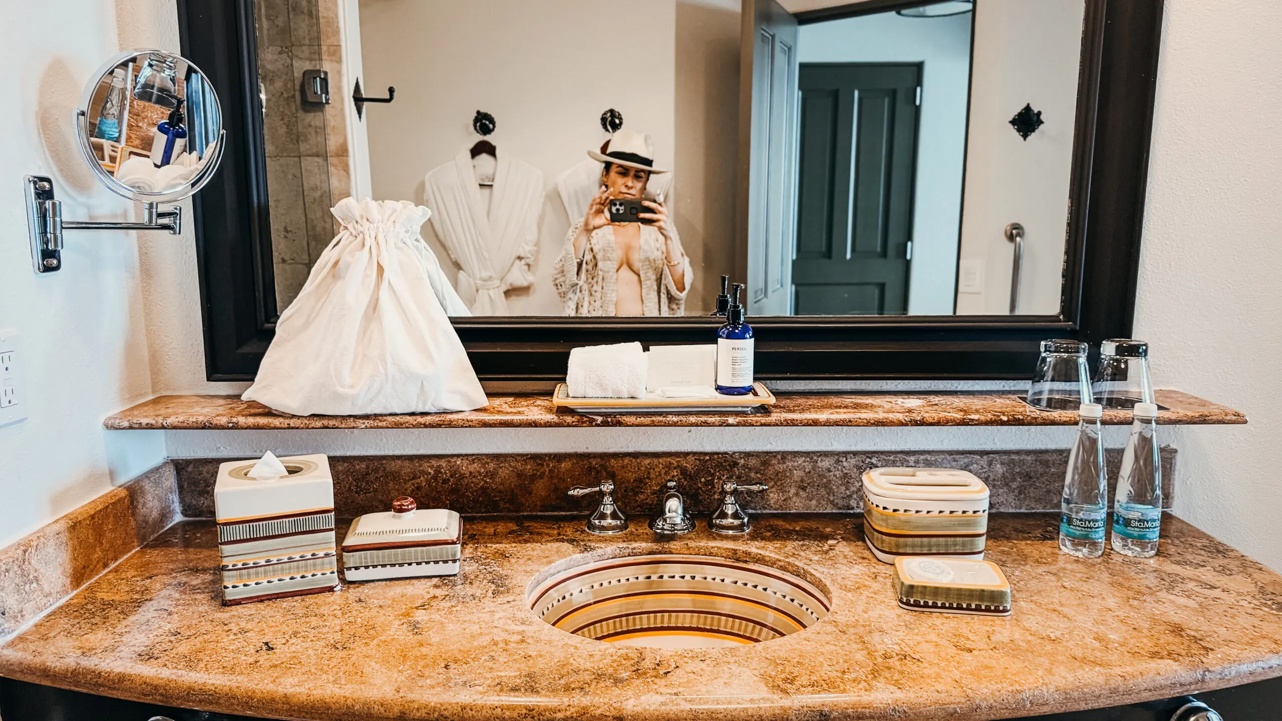 Elegant wedding dresses displayed on mannequins near a luxurious bathroom sink.