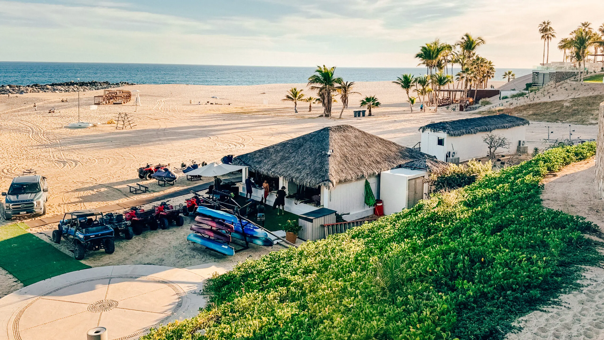 Beachside hut with surfboards by the sandy shore.