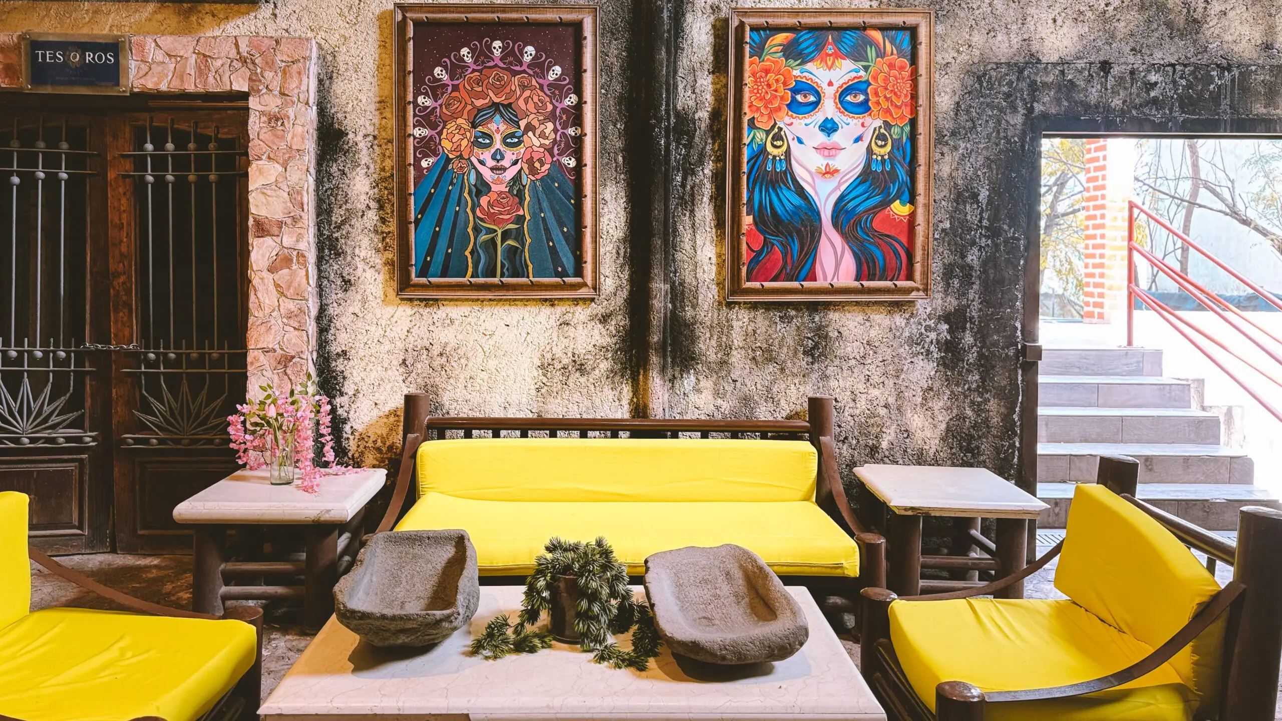 Cozy seating area with vibrant art and yellow sofa.