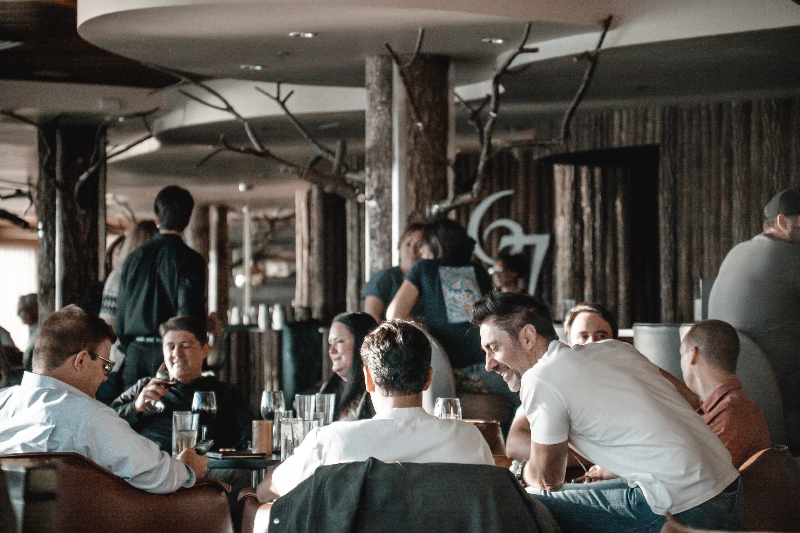 People enjoying drinks and conversation in a cozy bar setting.