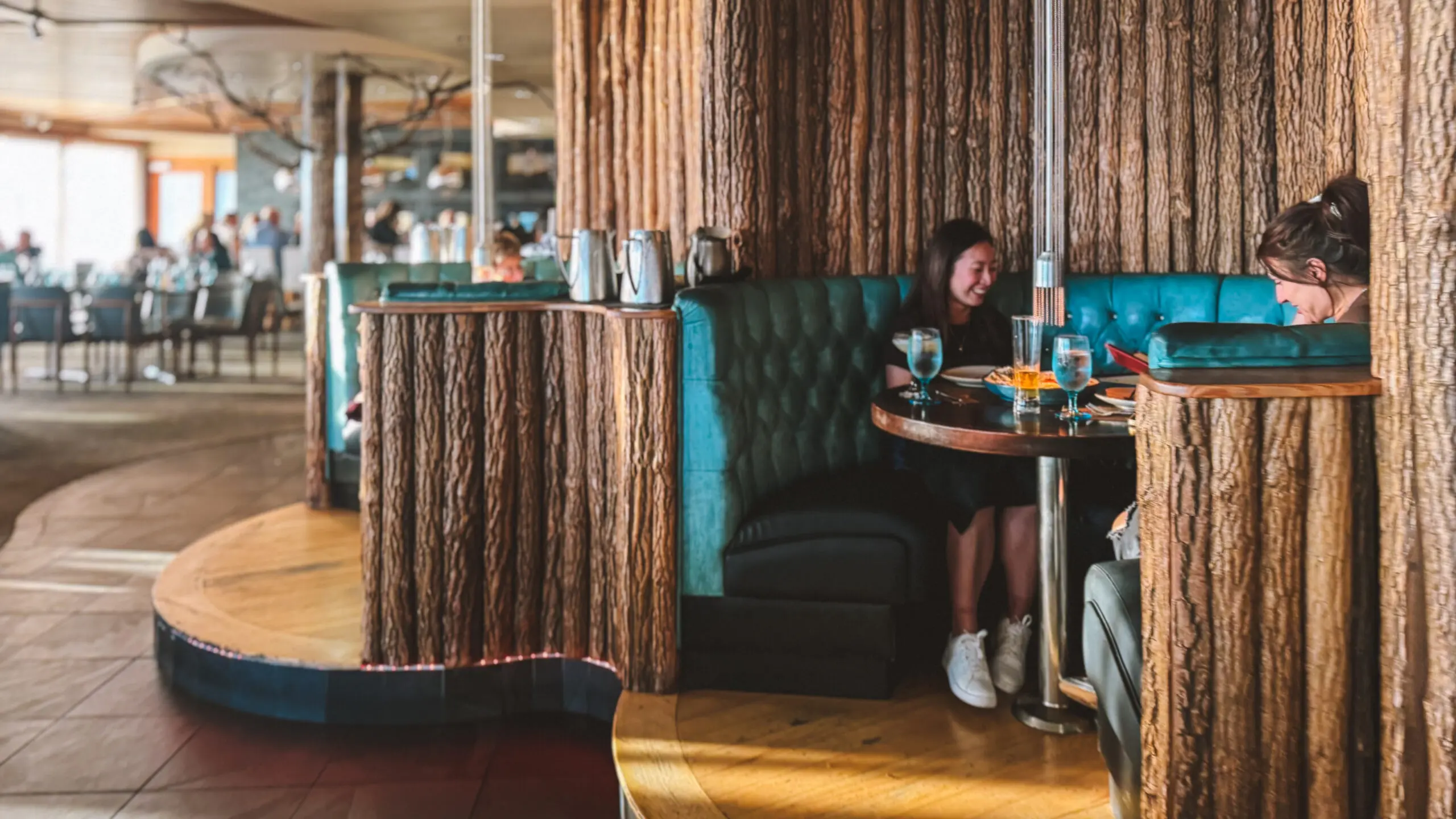Woman sitting alone at a cozy restaurant booth with a meal.