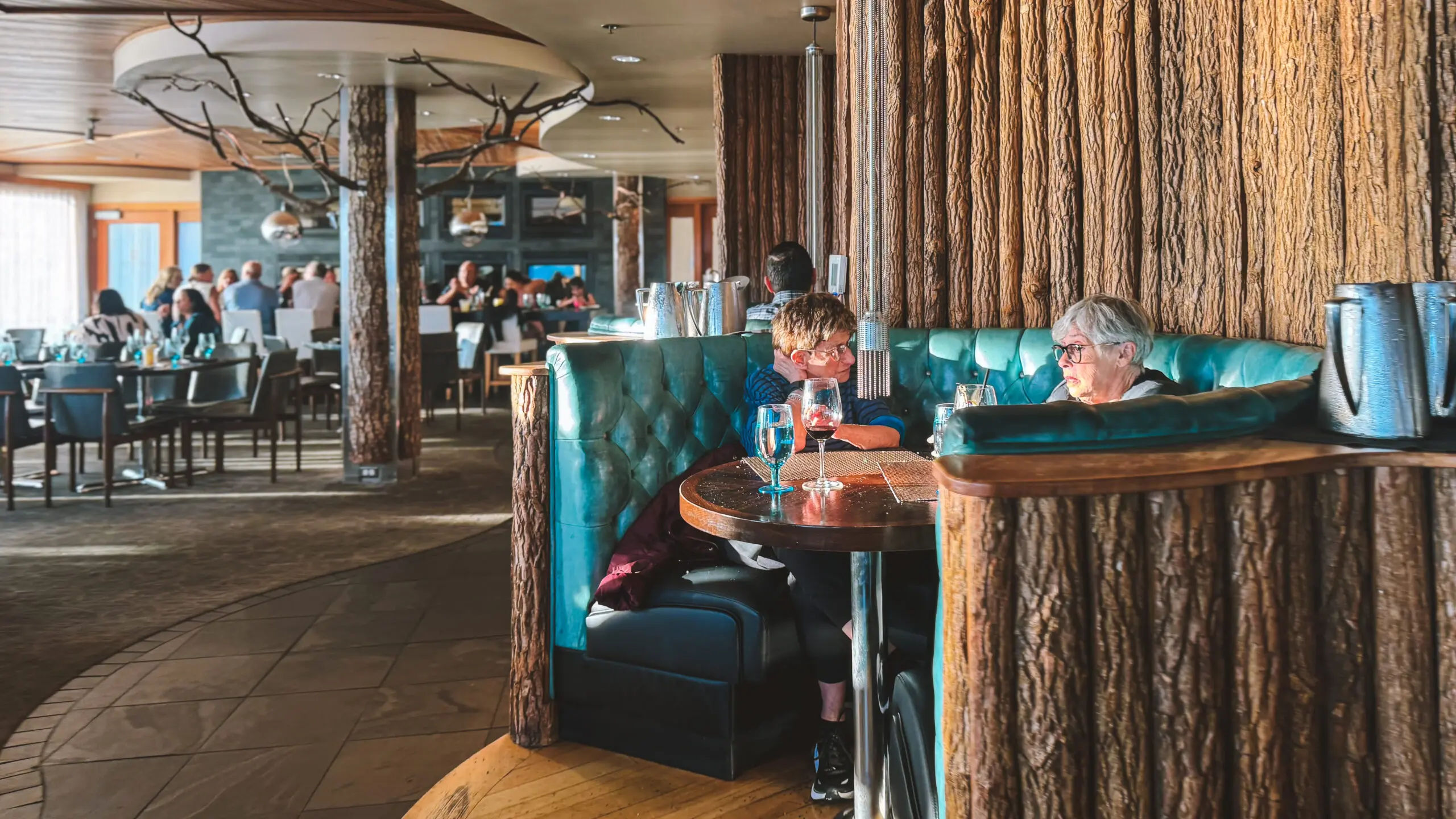 Children sitting in a cozy restaurant booth with wooden decor.