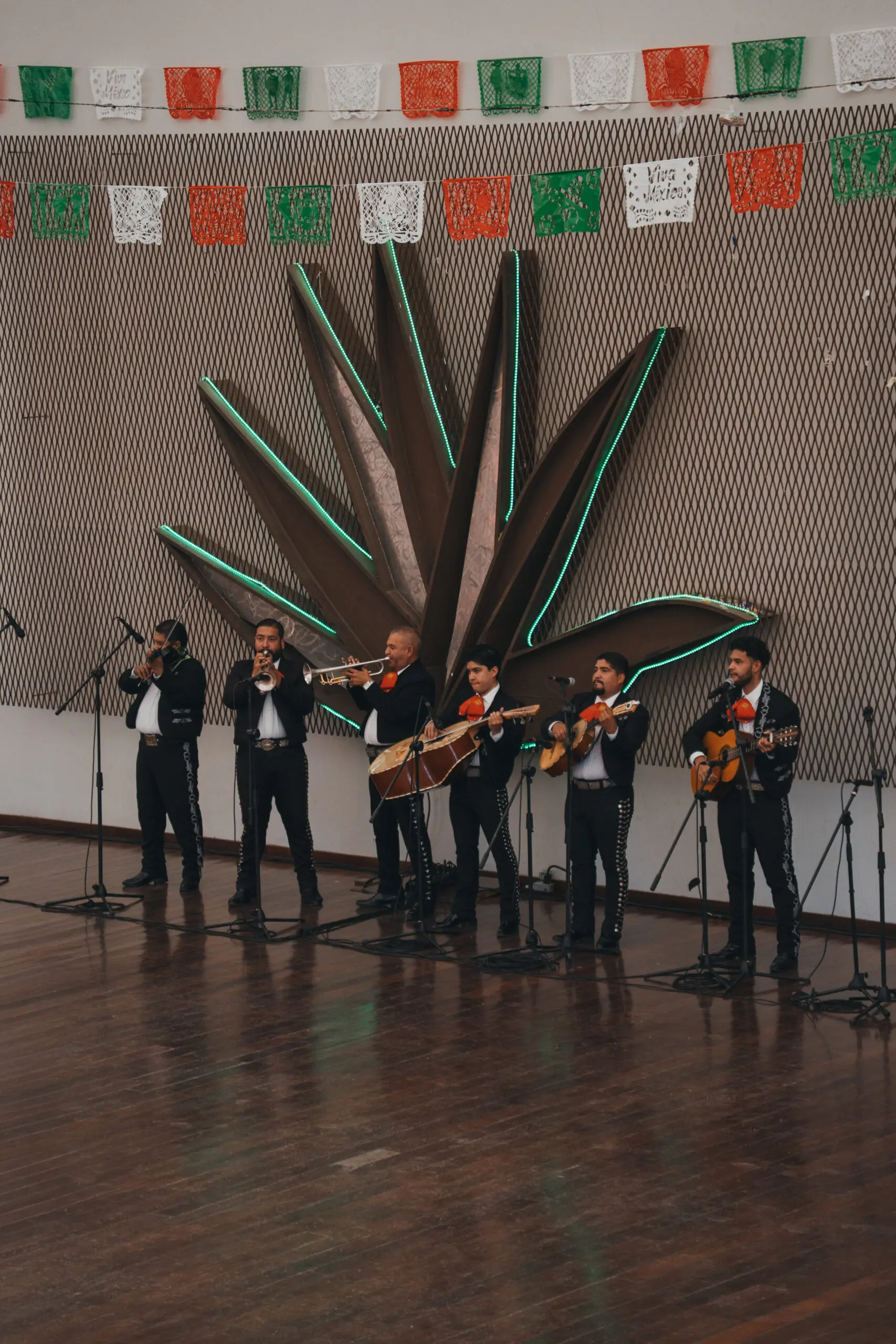 A mariachi band performing indoors with traditional attire and instruments.