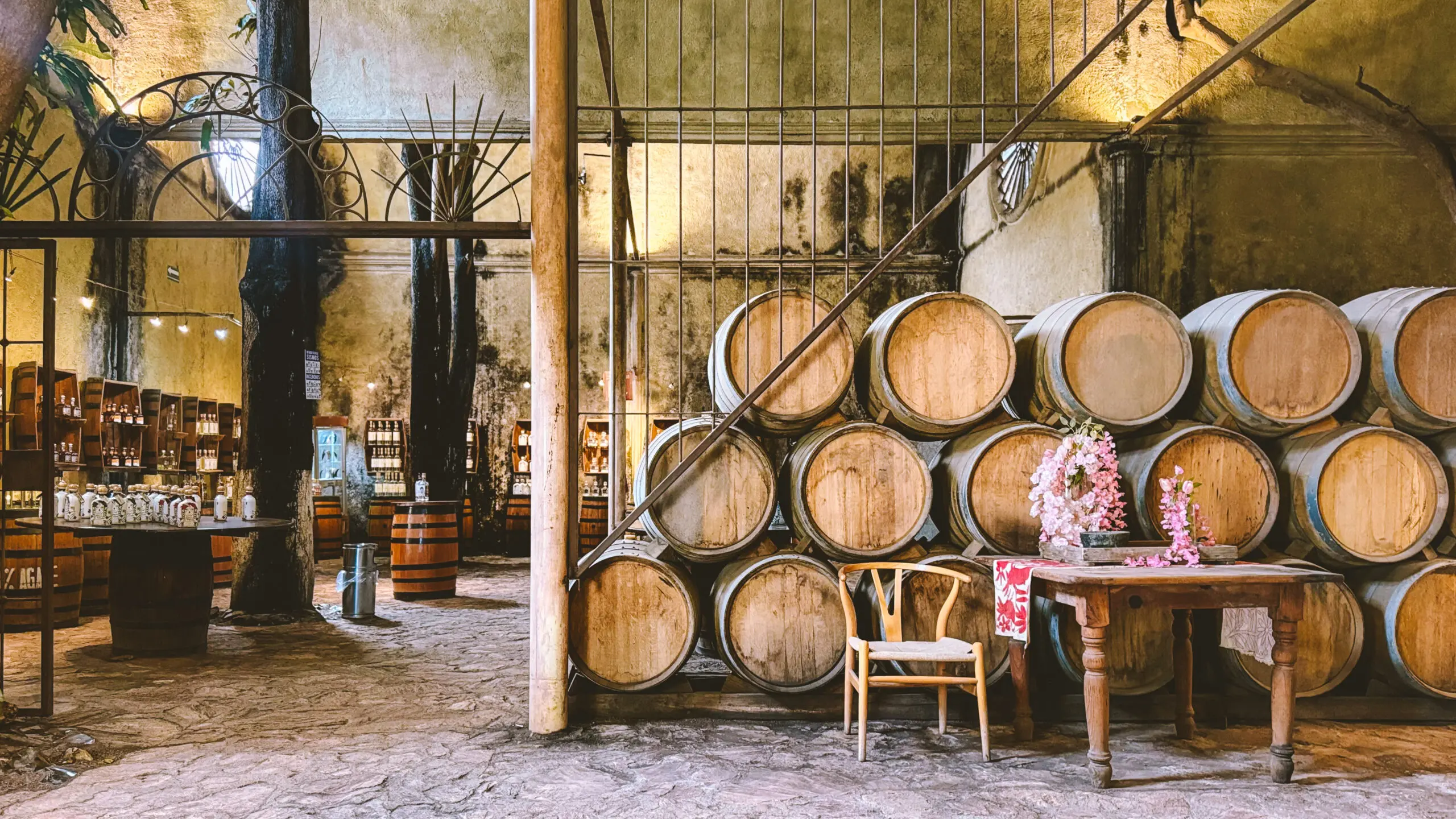 Rustic wine cellar with wooden barrels and cozy chairs.