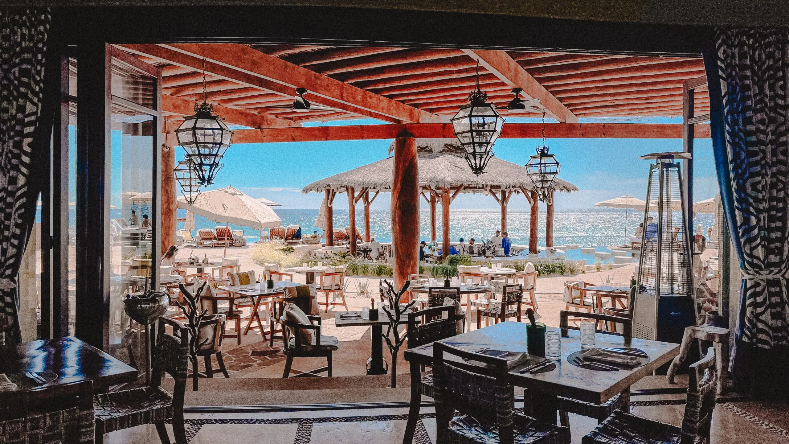 Seaside restaurant with wooden furniture and ocean views.