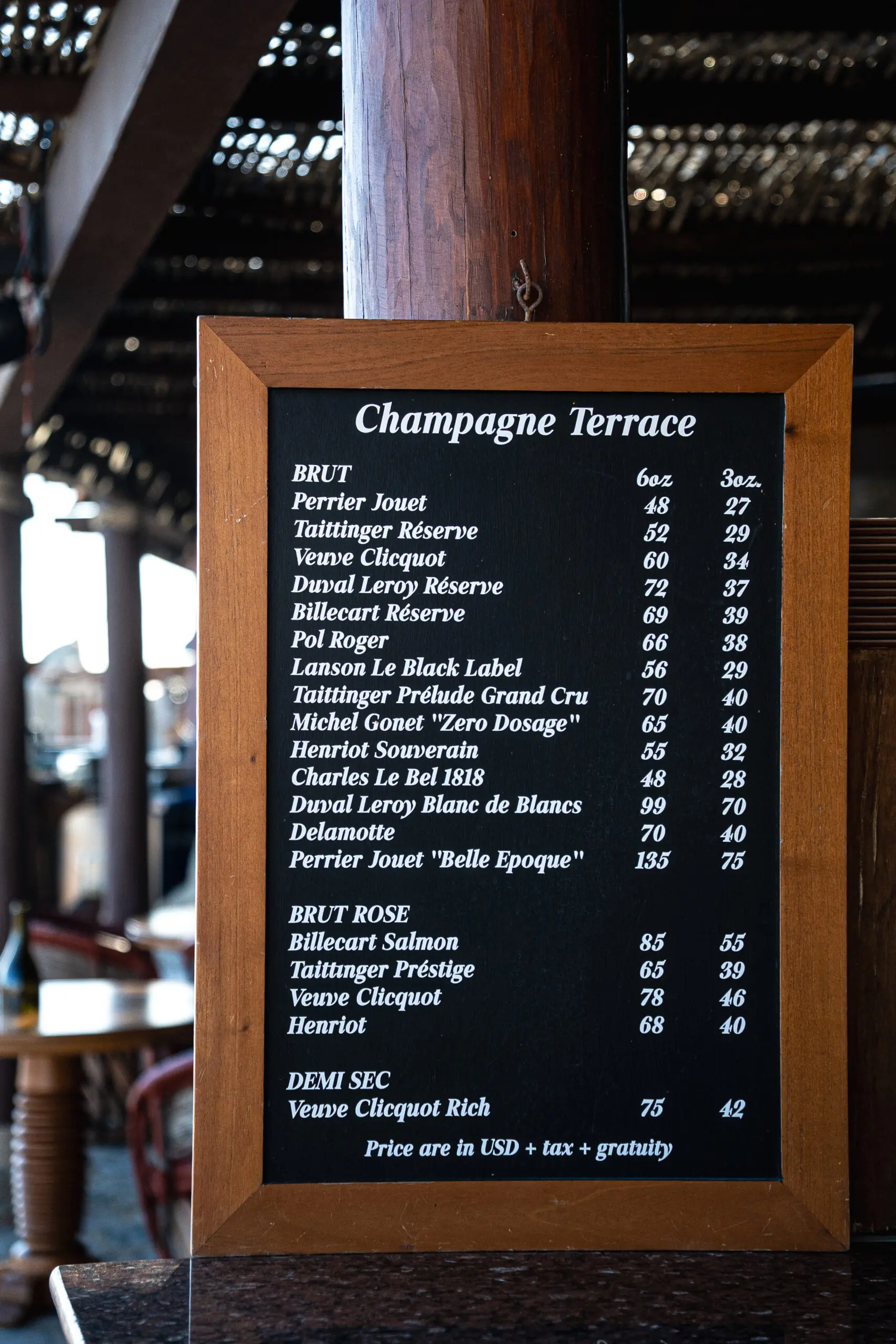A menu board listing various wines and champagnes with prices.