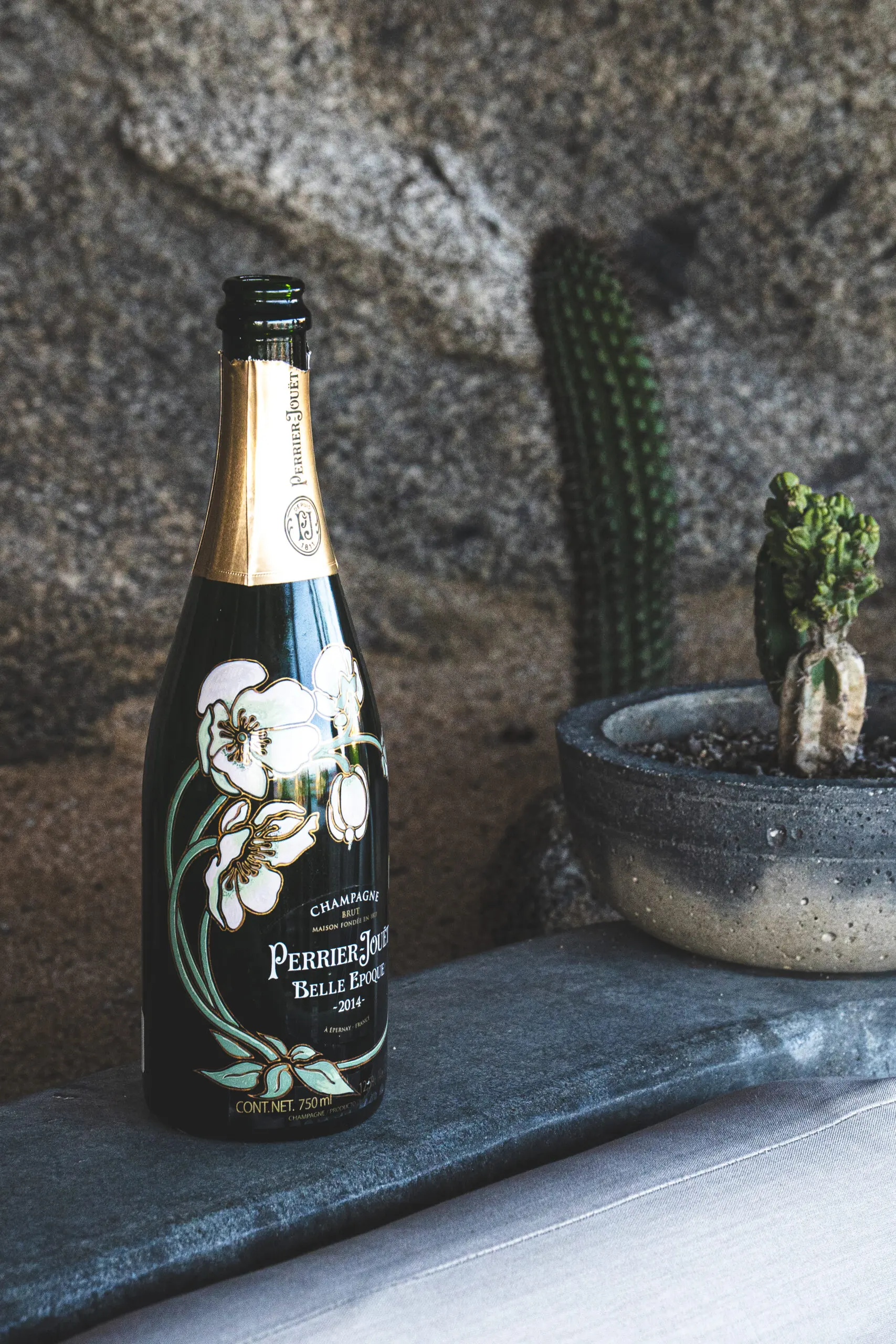 Elegant bottle of sparkling wine with floral design on label.