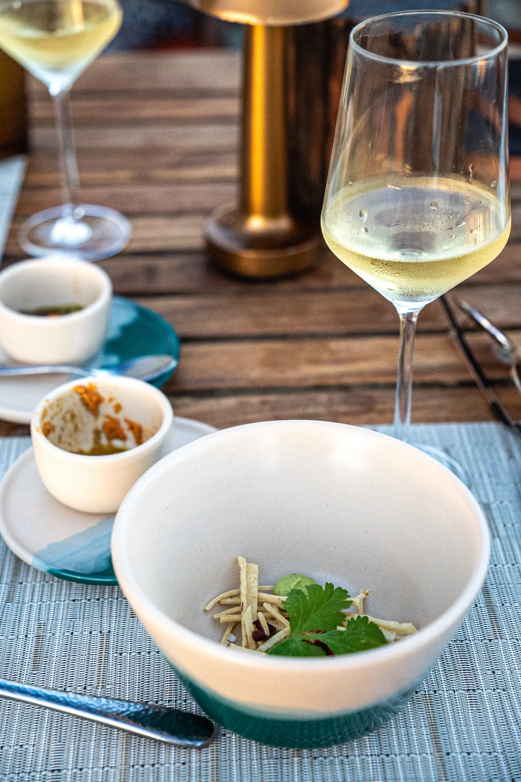 A sophisticated dining setup with white wine and a gourmet dish.