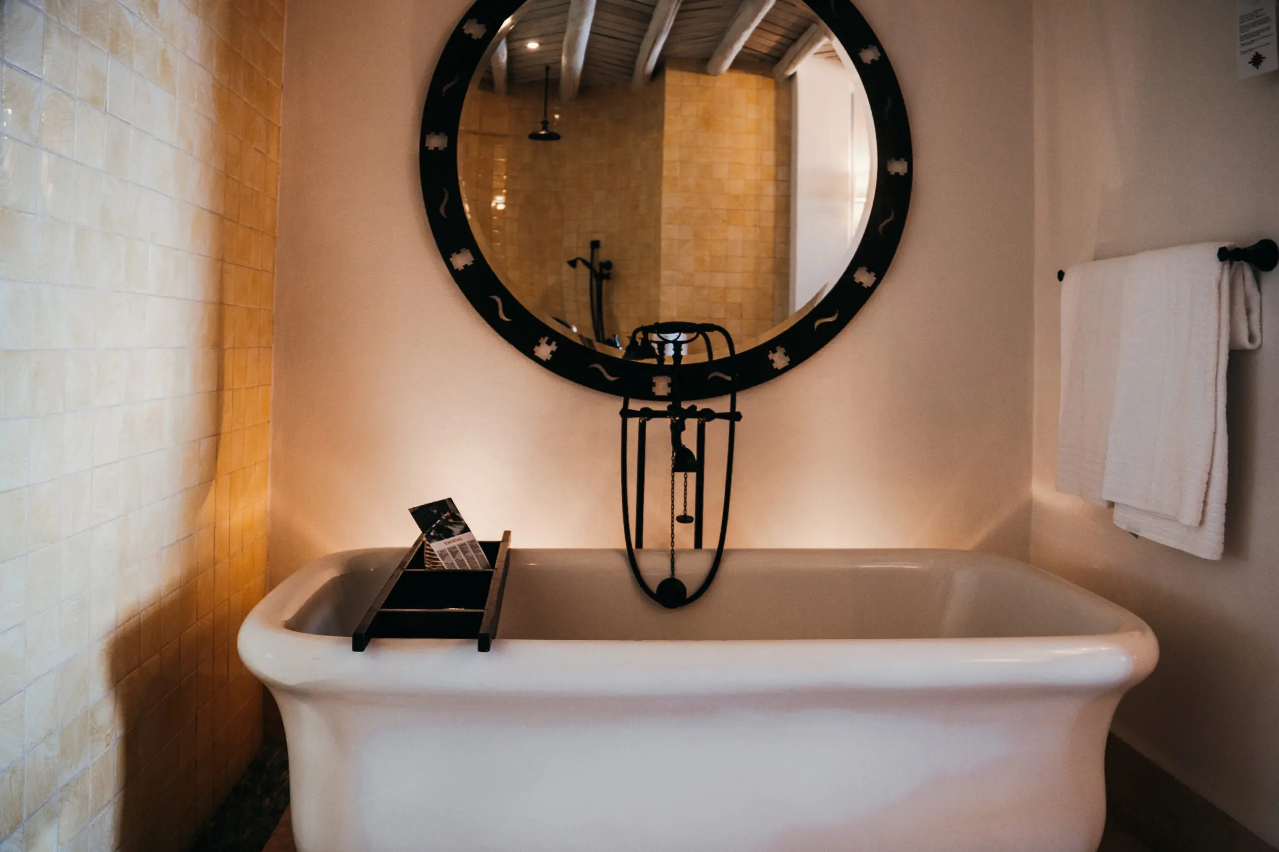 Elegant bathroom with a vintage-style bathtub and a round mirror.