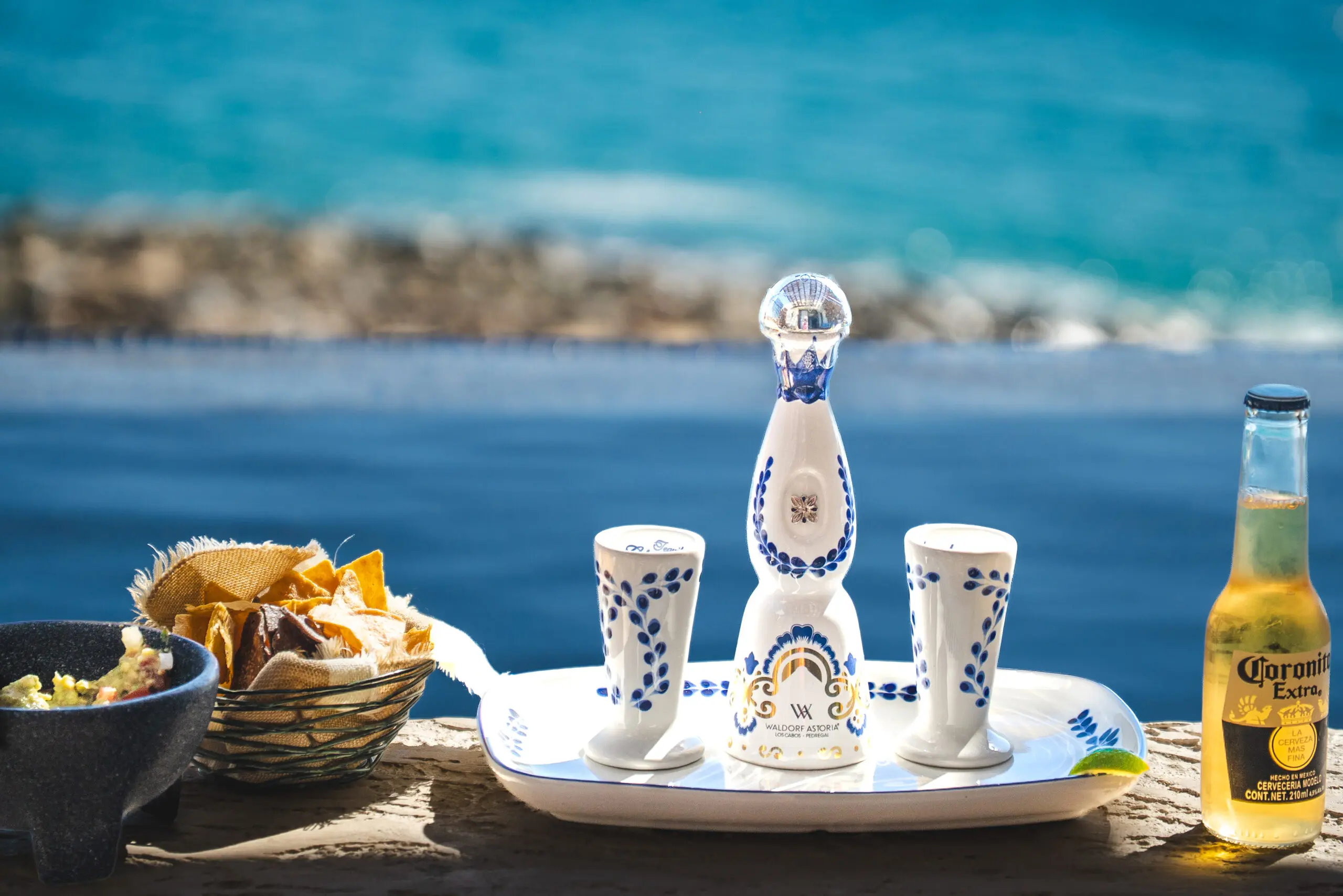 Decorative ceramic tequila set with glasses by the sea.