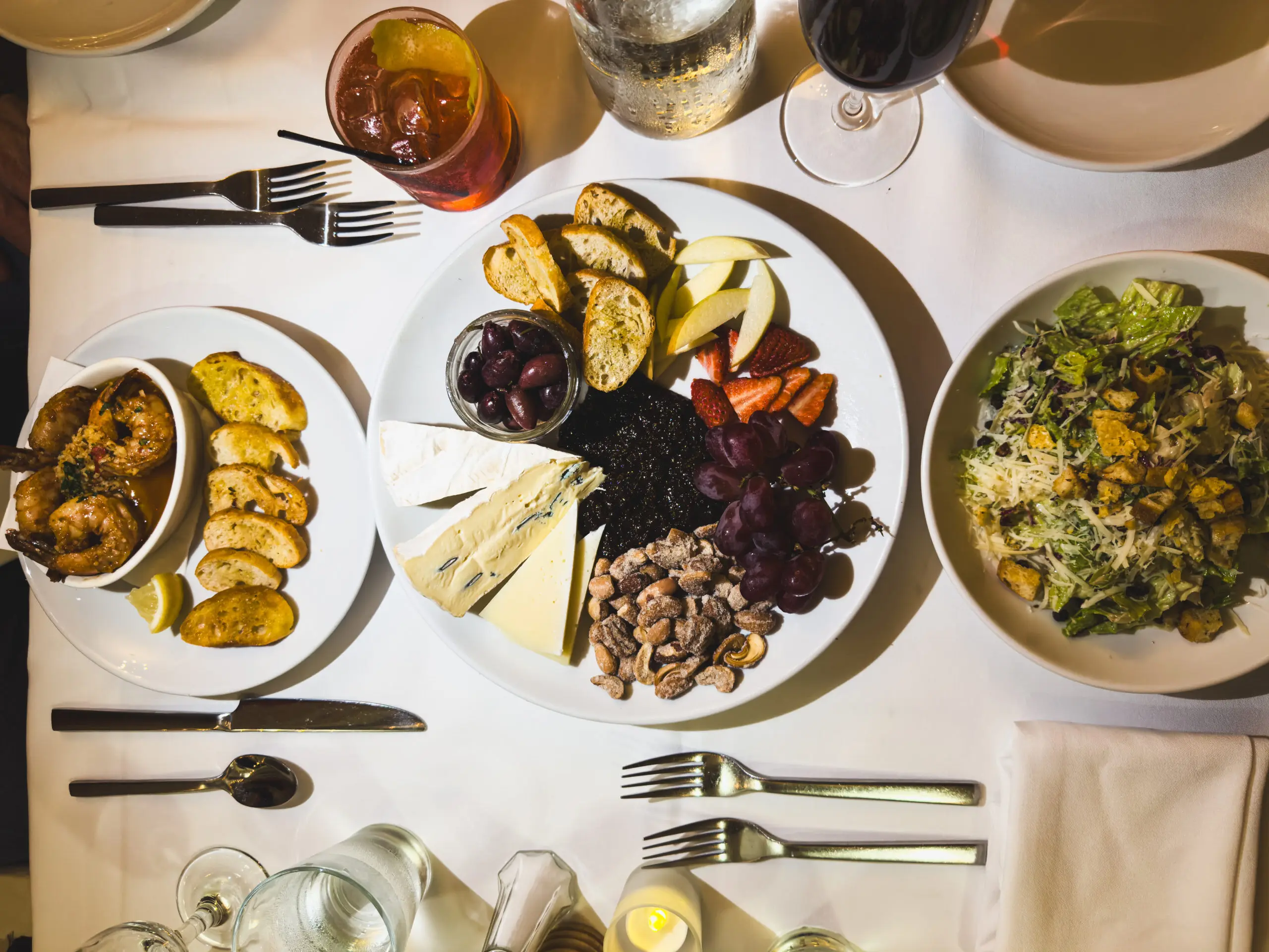 A table set with various dishes including roasted vegetables and a salad.