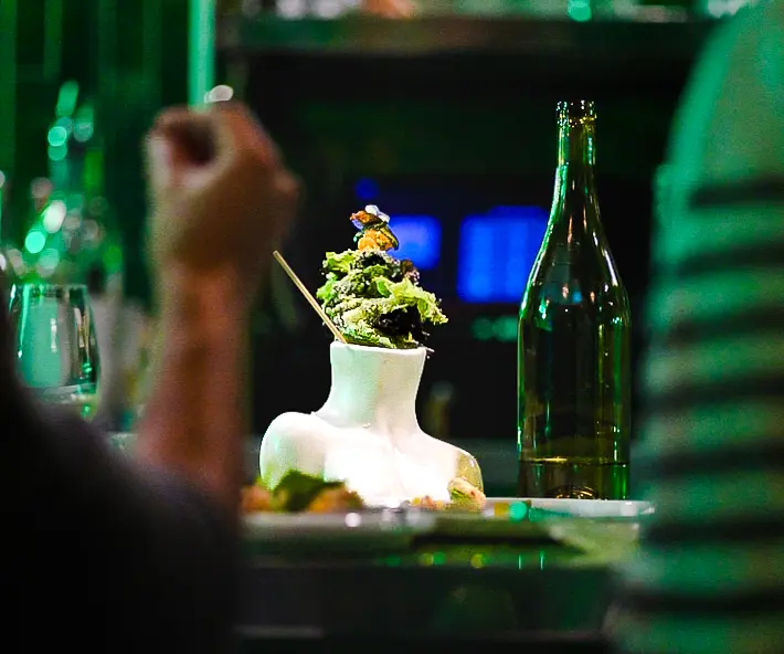 woman with a bob haircut holding a camera up to her face with a light in the background