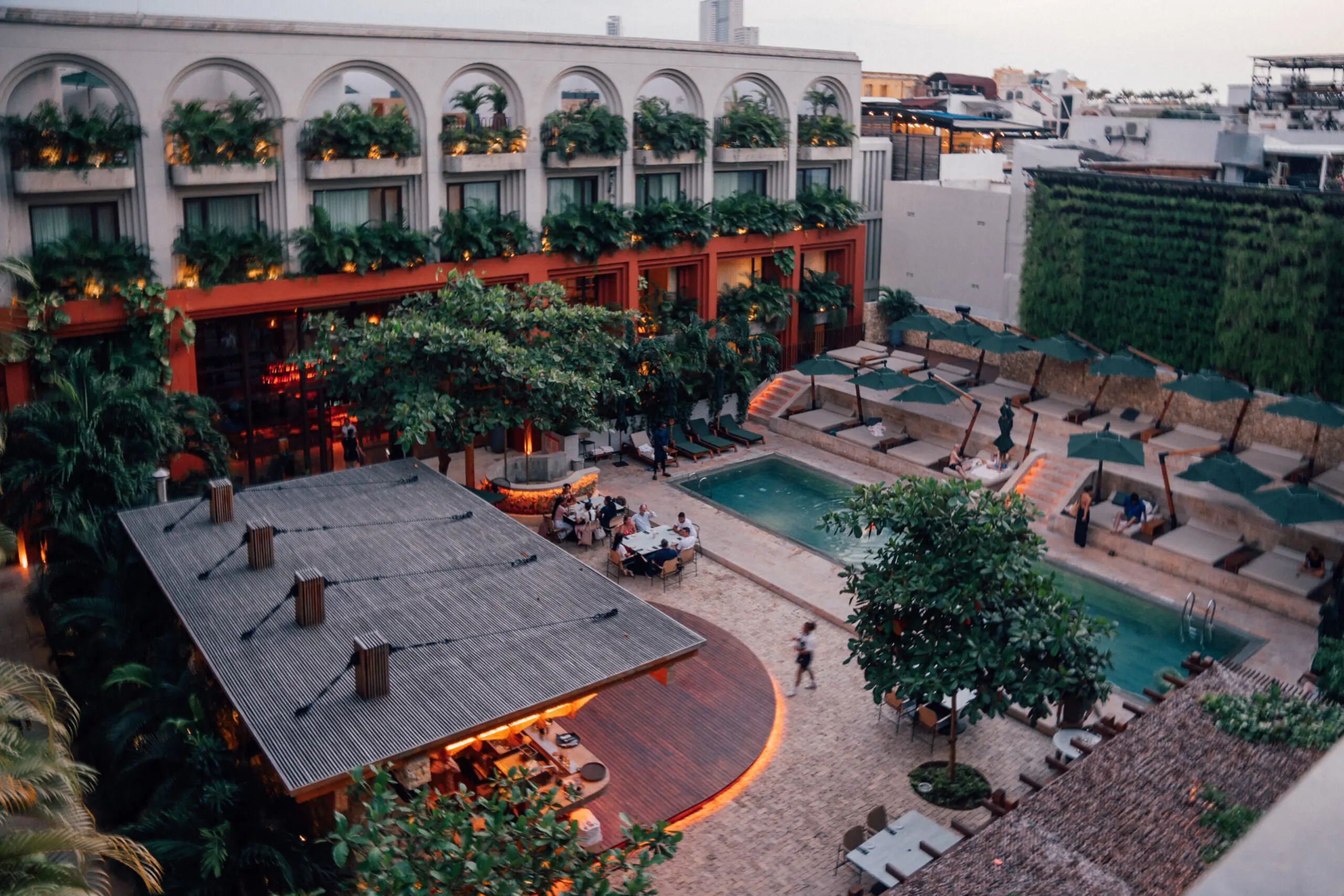 woman with a bob haircut holding a camera up to her face with a light in the background