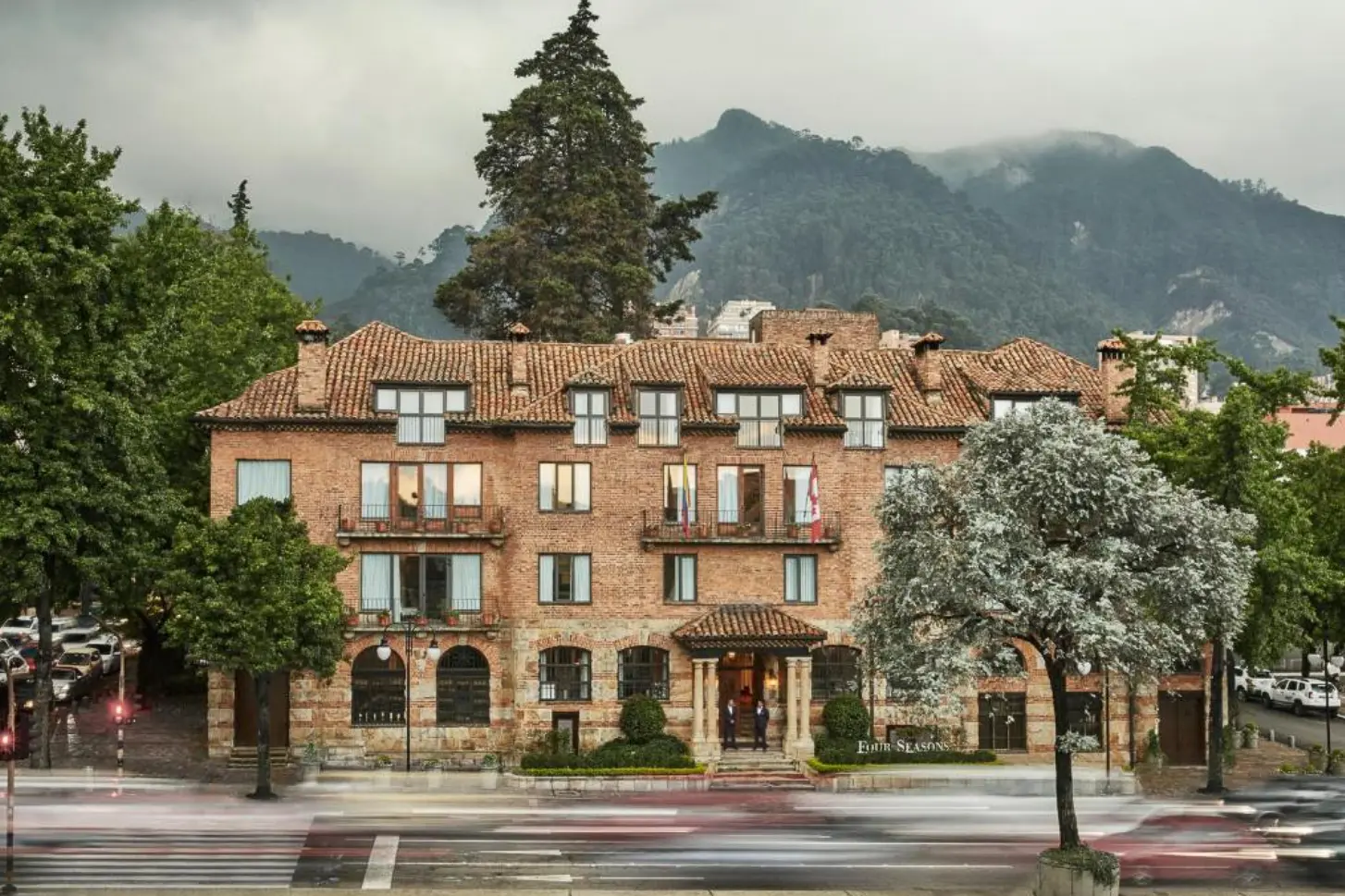 woman with a bob haircut holding a camera up to her face with a light in the background