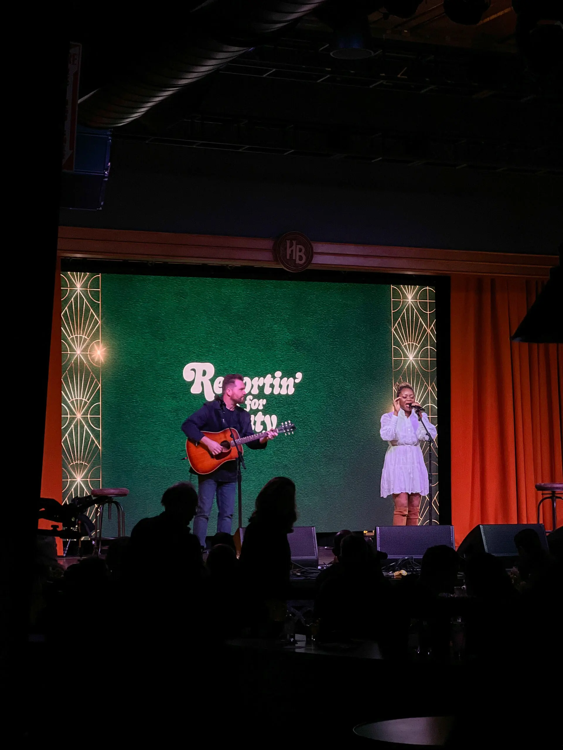 woman with a bob haircut holding a camera up to her face with a light in the background