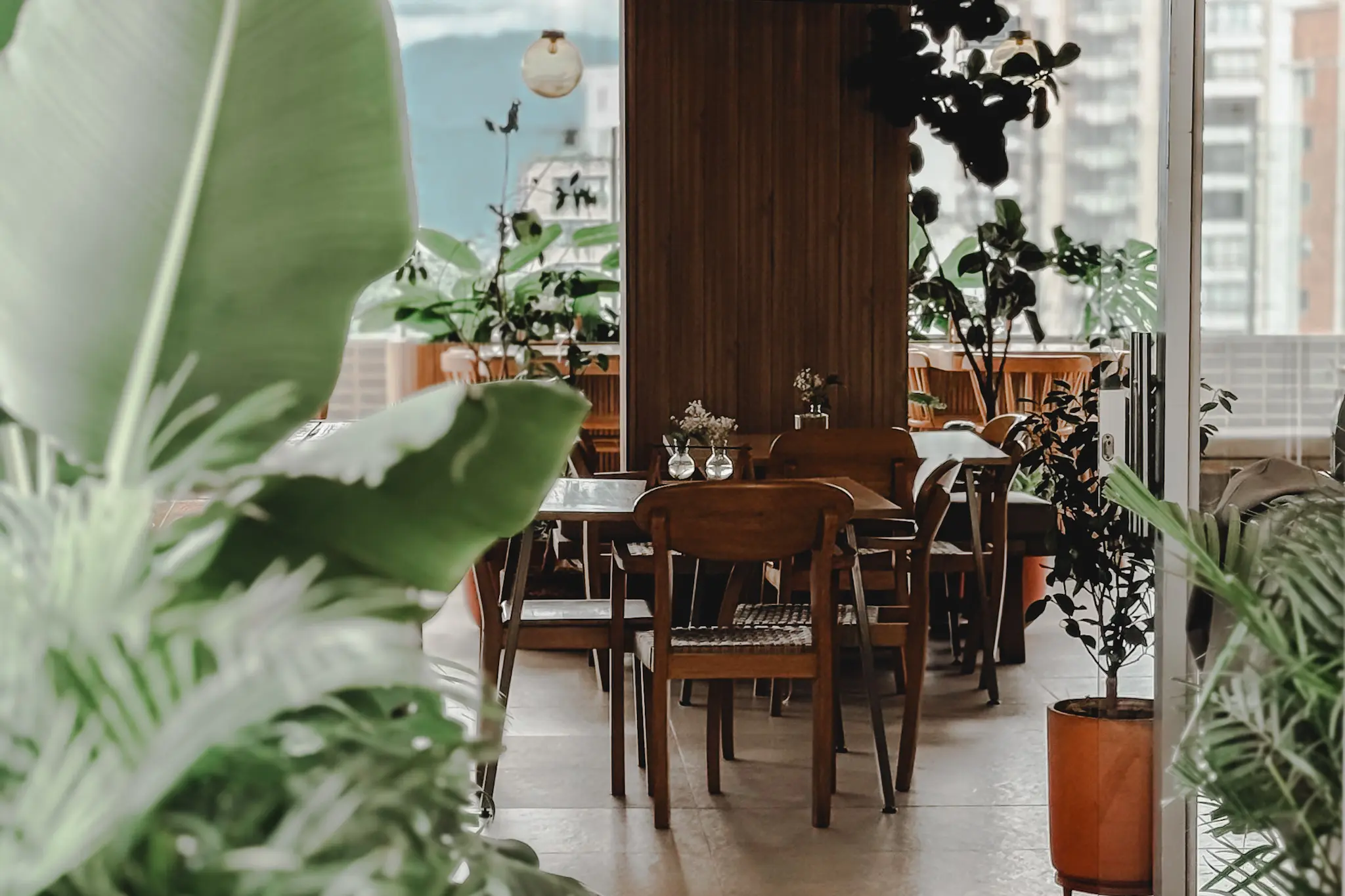 woman with a bob haircut holding a camera up to her face with a light in the background