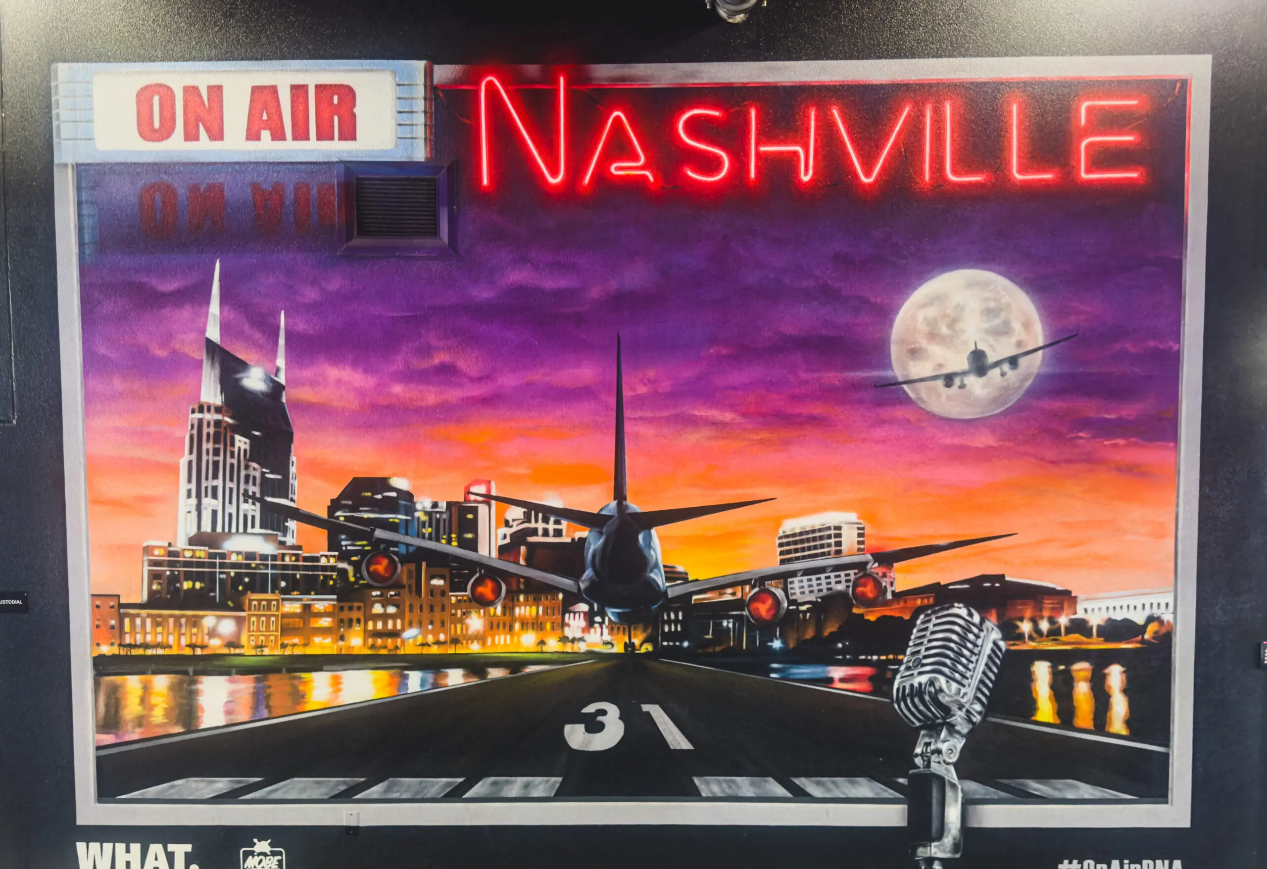 woman with a bob haircut holding a camera up to her face with a light in the background