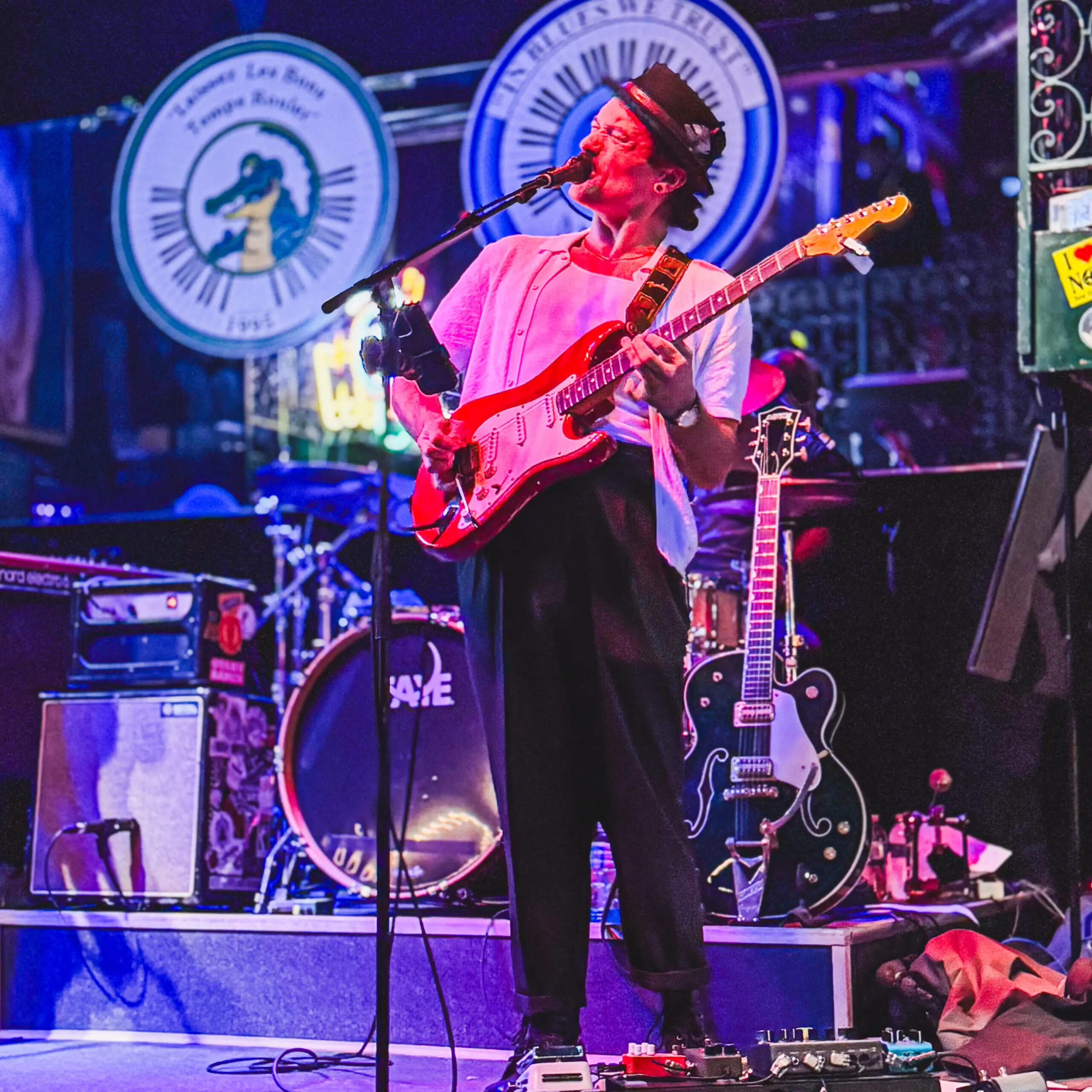 woman with a bob haircut holding a camera up to her face with a light in the background