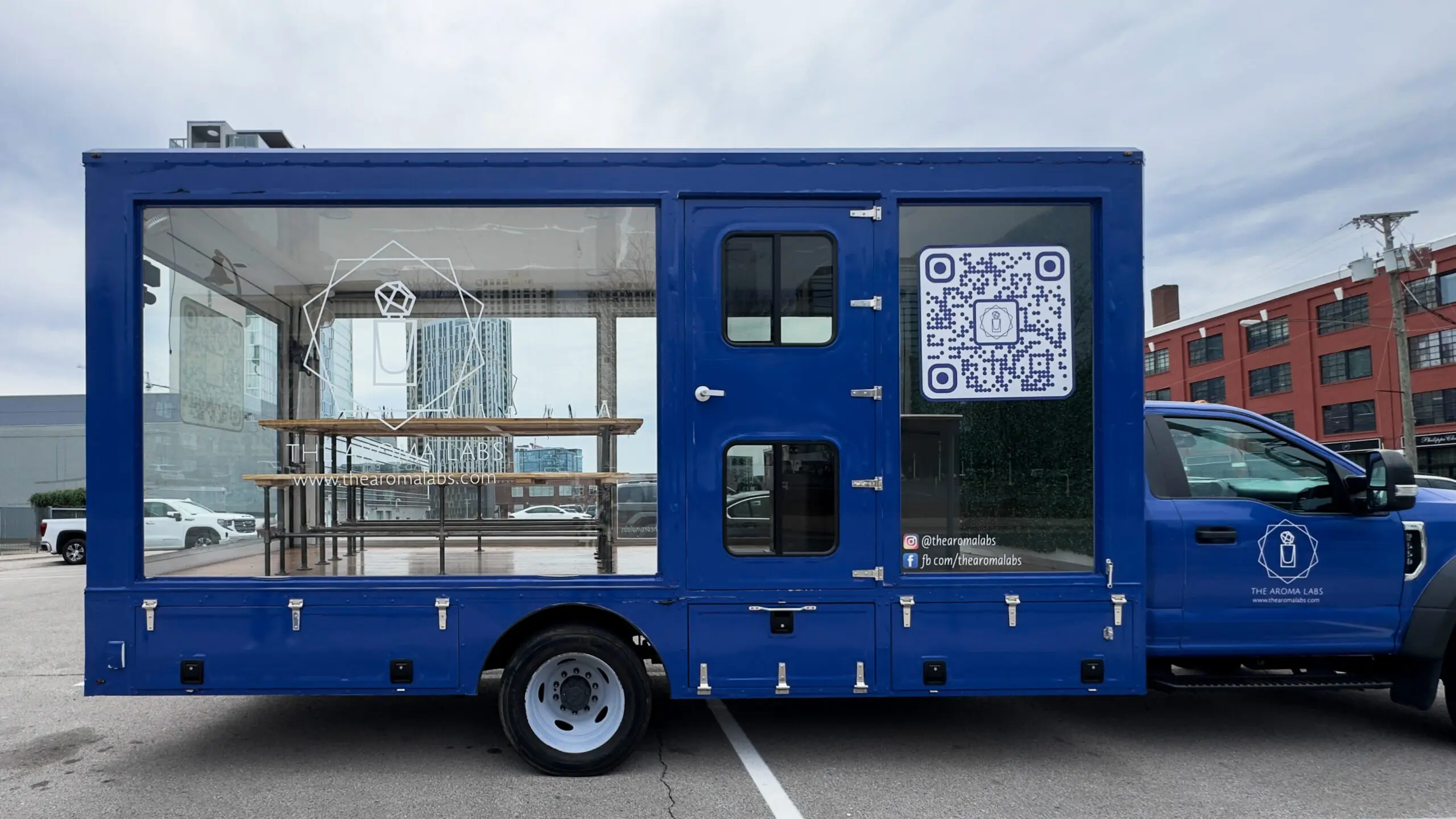 woman with a bob haircut holding a camera up to her face with a light in the background
