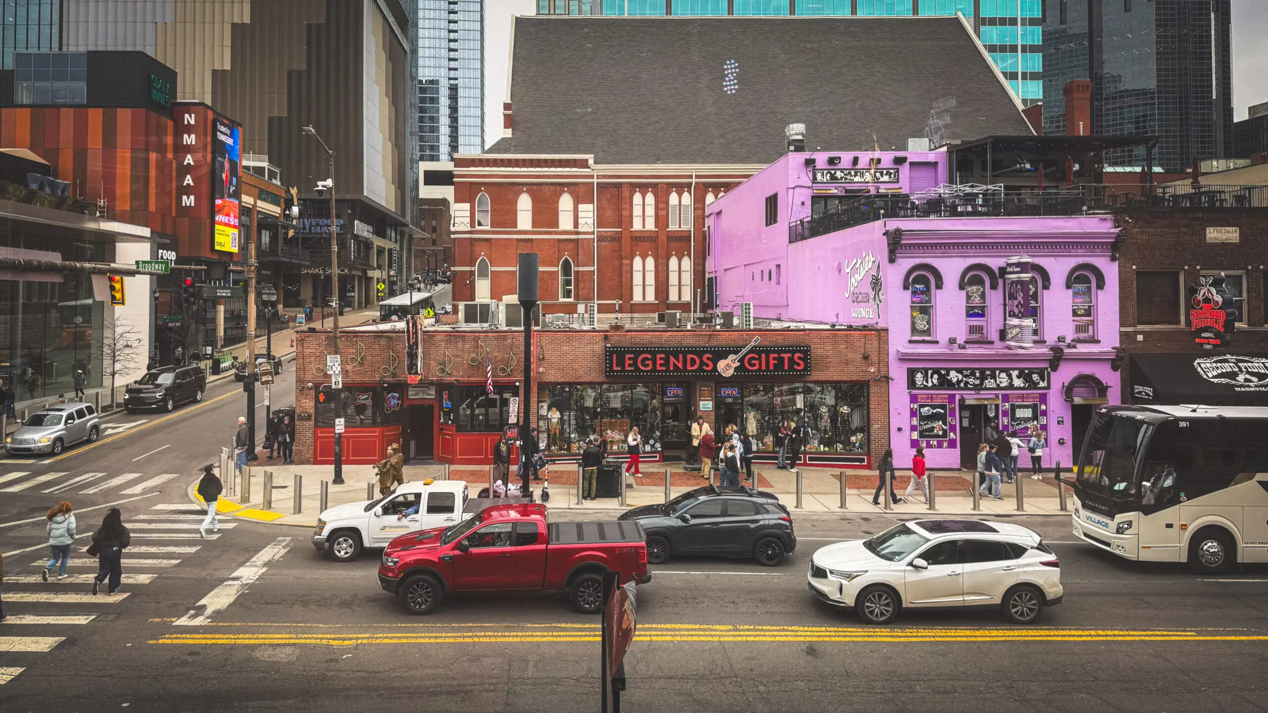 woman with a bob haircut holding a camera up to her face with a light in the background
