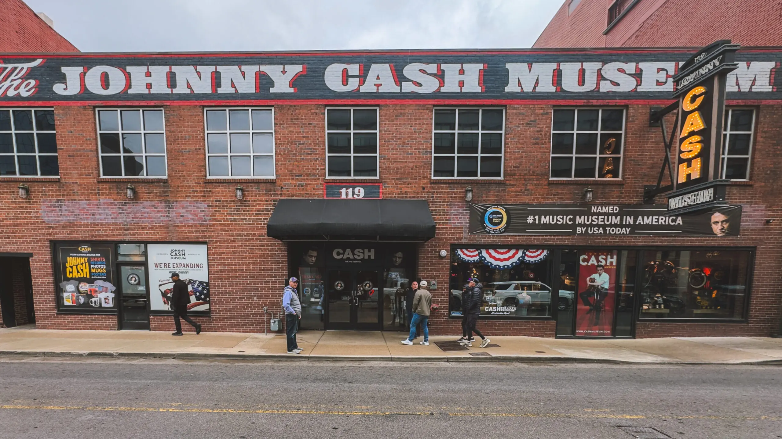 woman with a bob haircut holding a camera up to her face with a light in the background