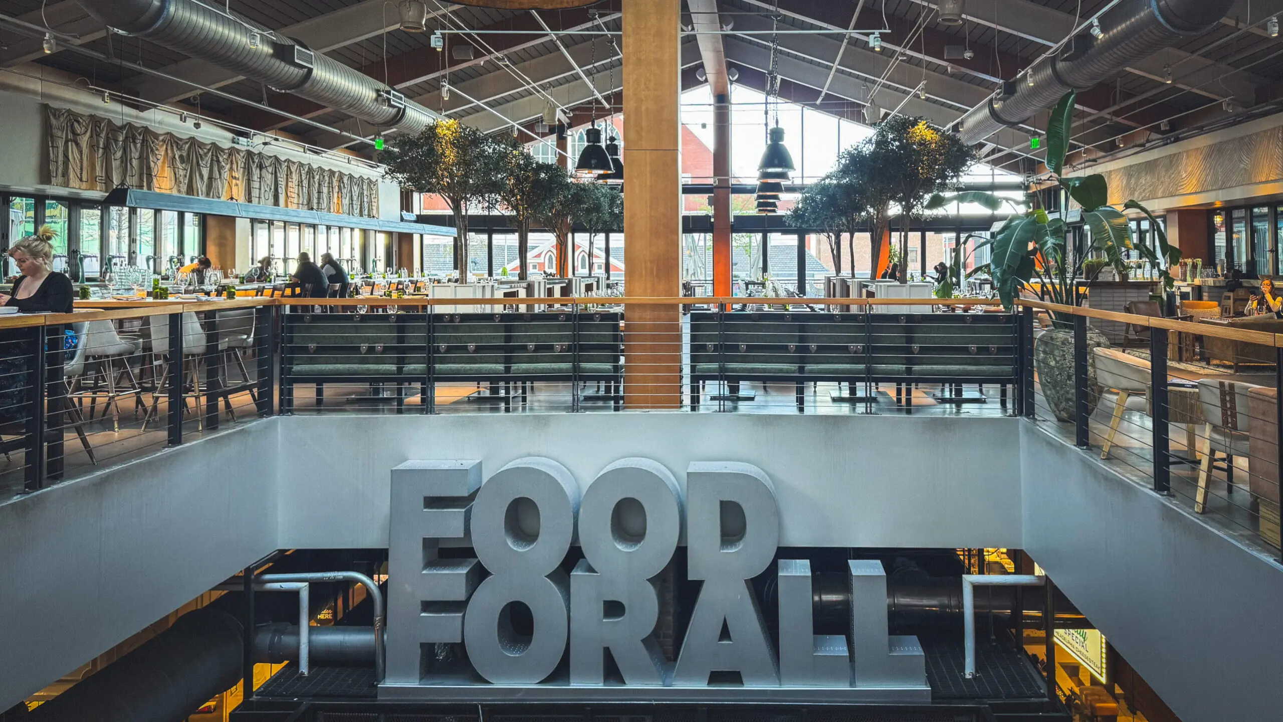 woman with a bob haircut holding a camera up to her face with a light in the background