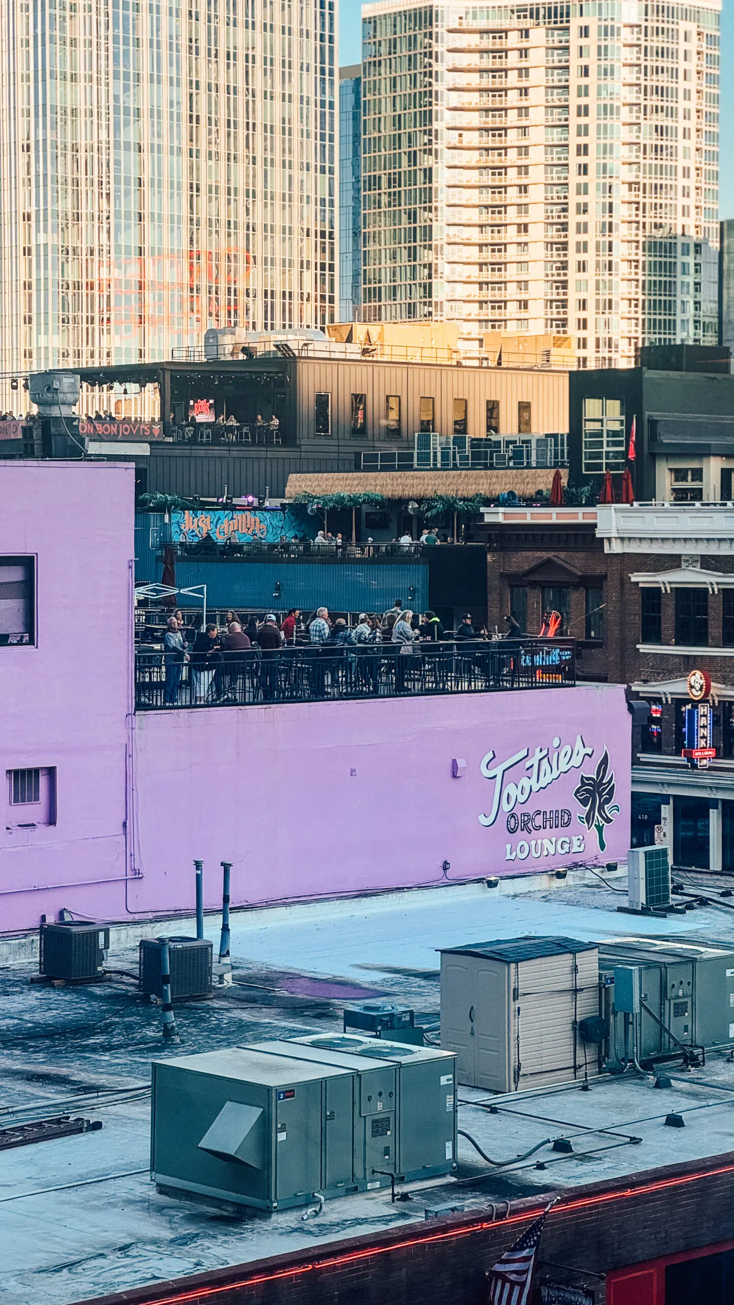 woman with a bob haircut holding a camera up to her face with a light in the background