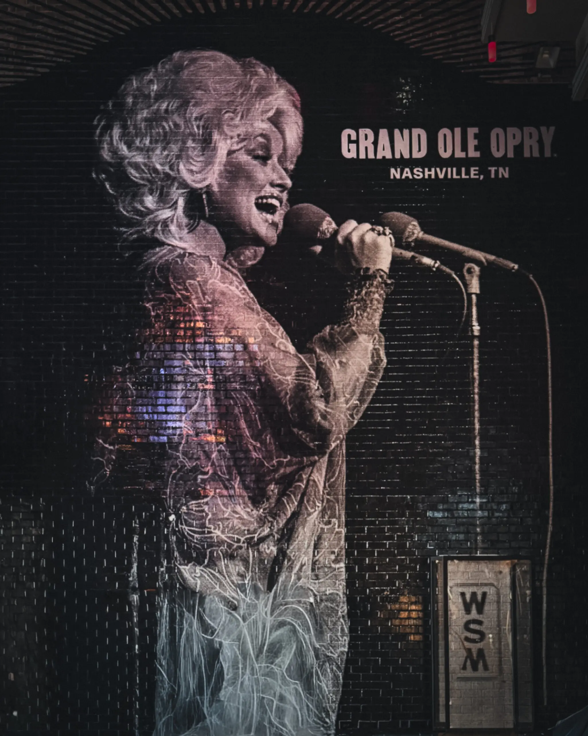 woman with a bob haircut holding a camera up to her face with a light in the background