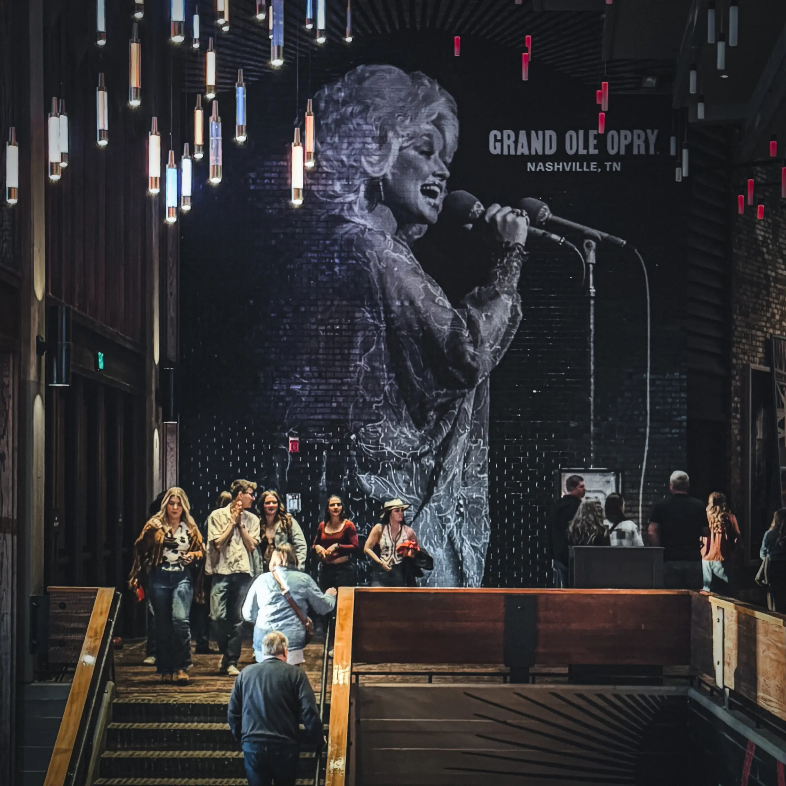 woman with a bob haircut holding a camera up to her face with a light in the background