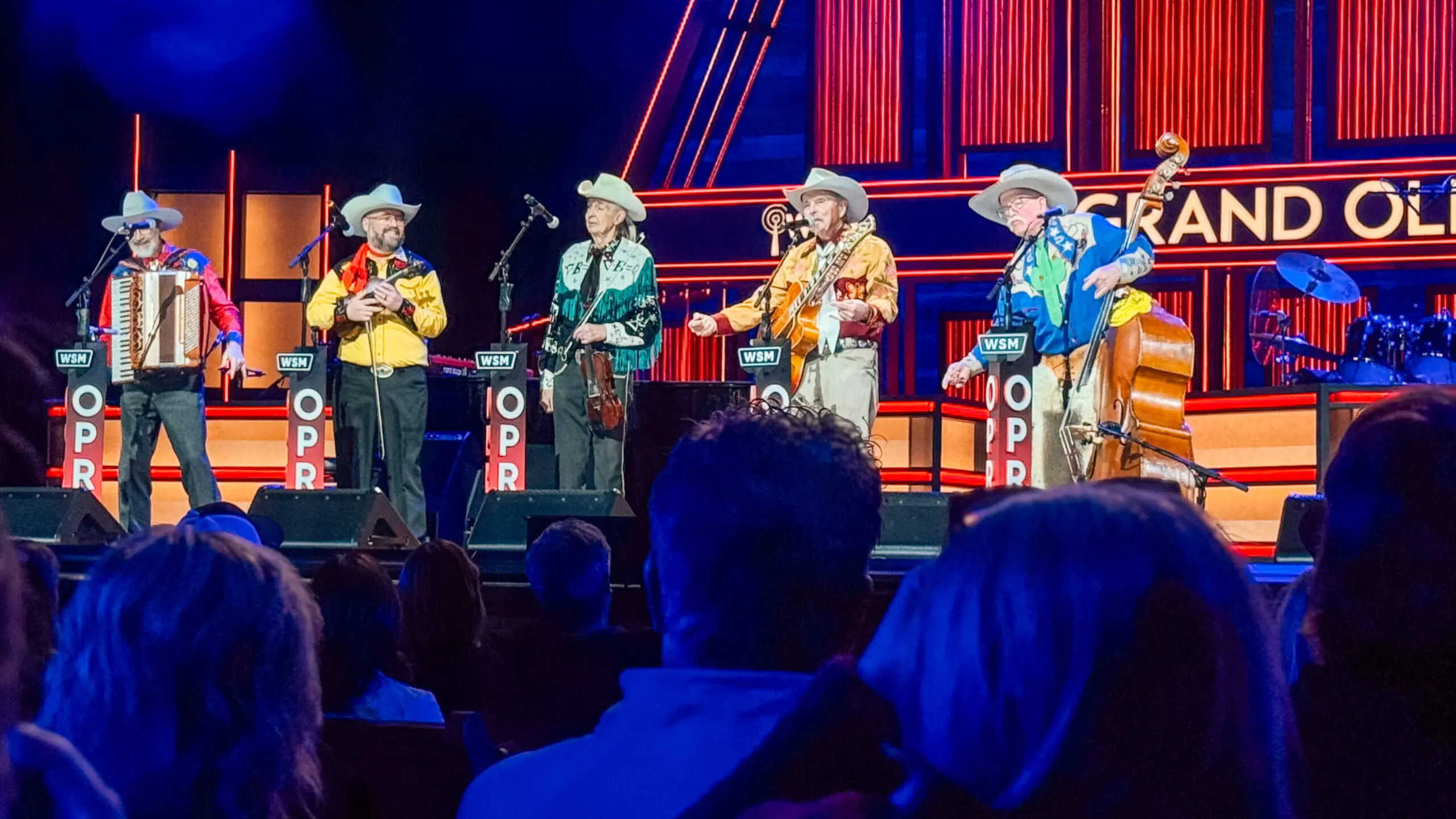 woman with a bob haircut holding a camera up to her face with a light in the background