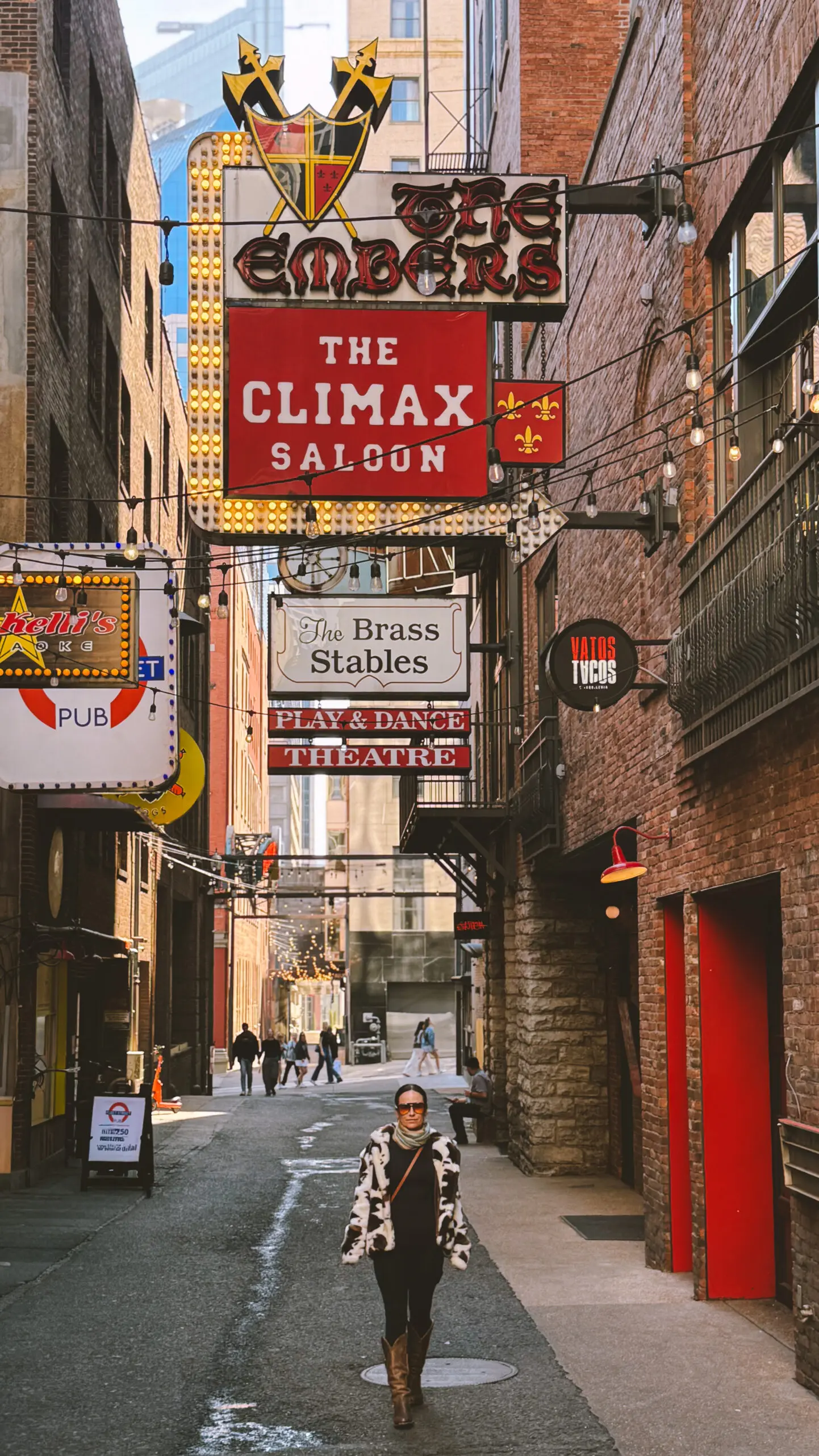 woman with a bob haircut holding a camera up to her face with a light in the background