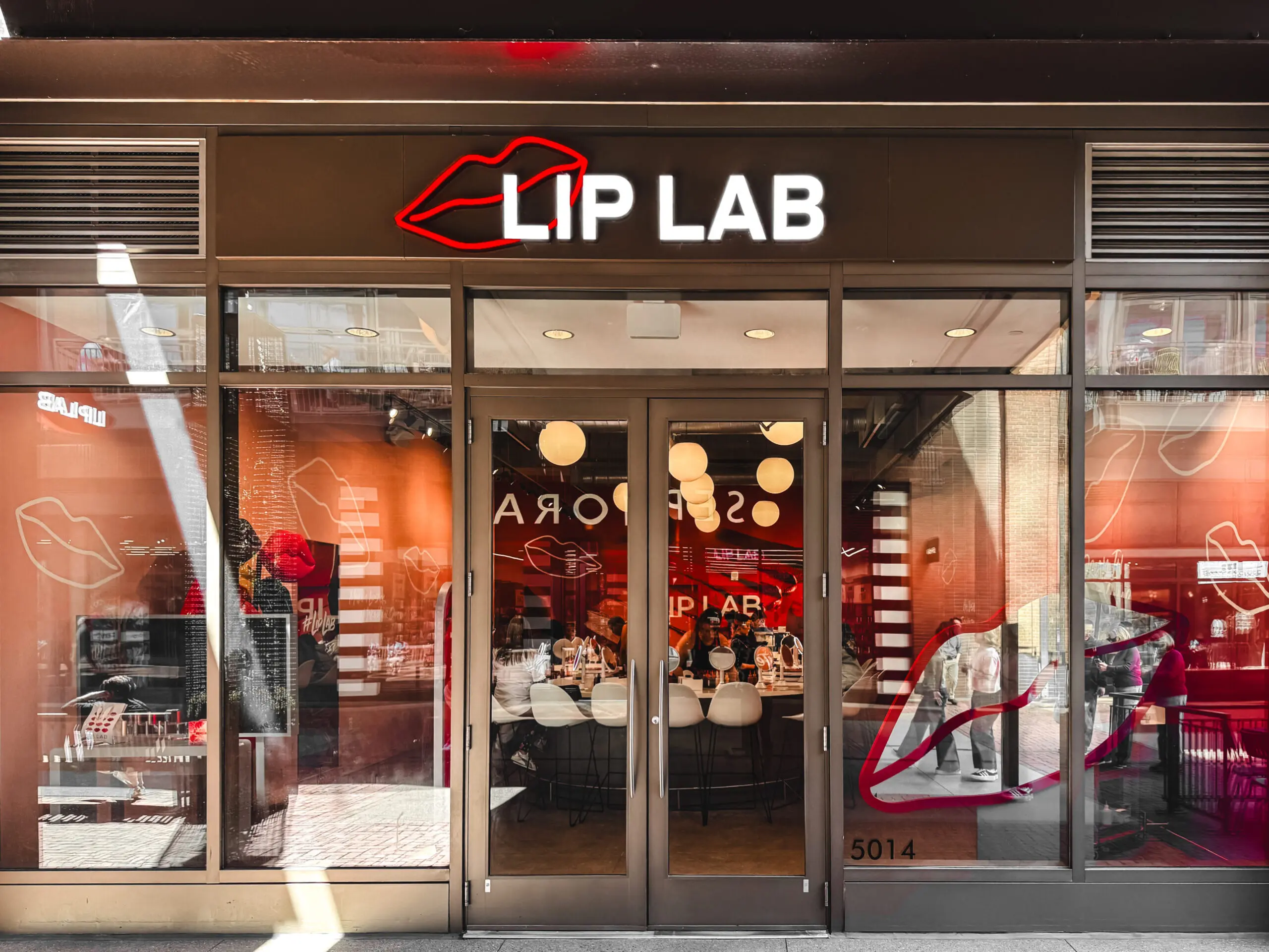 woman with a bob haircut holding a camera up to her face with a light in the background