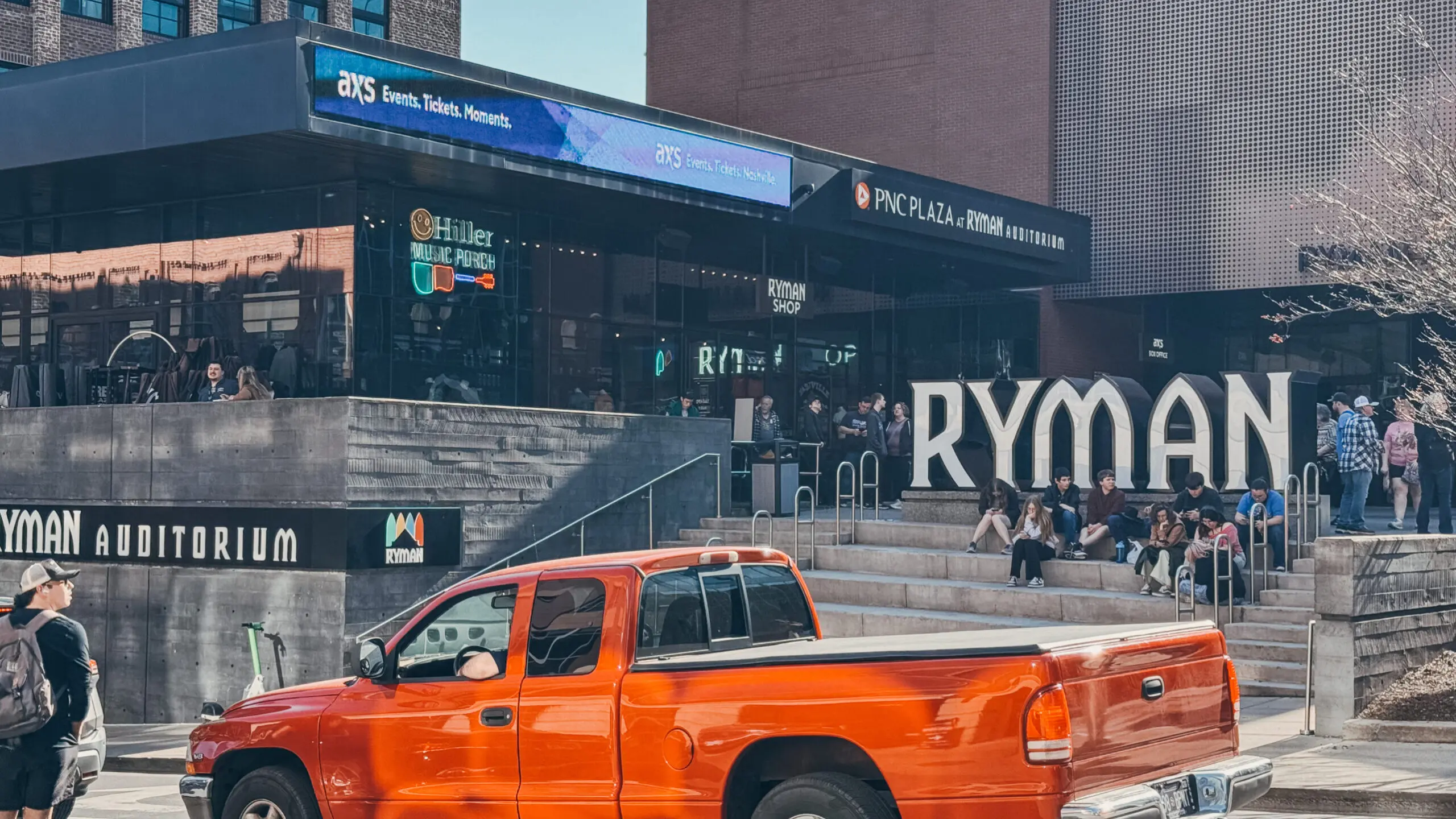 woman with a bob haircut holding a camera up to her face with a light in the background