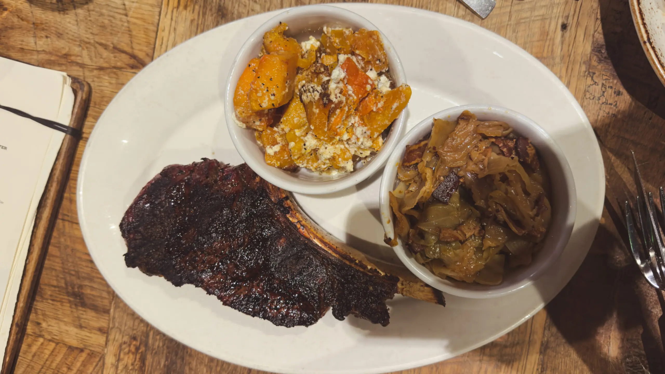woman with a bob haircut holding a camera up to her face with a light in the background