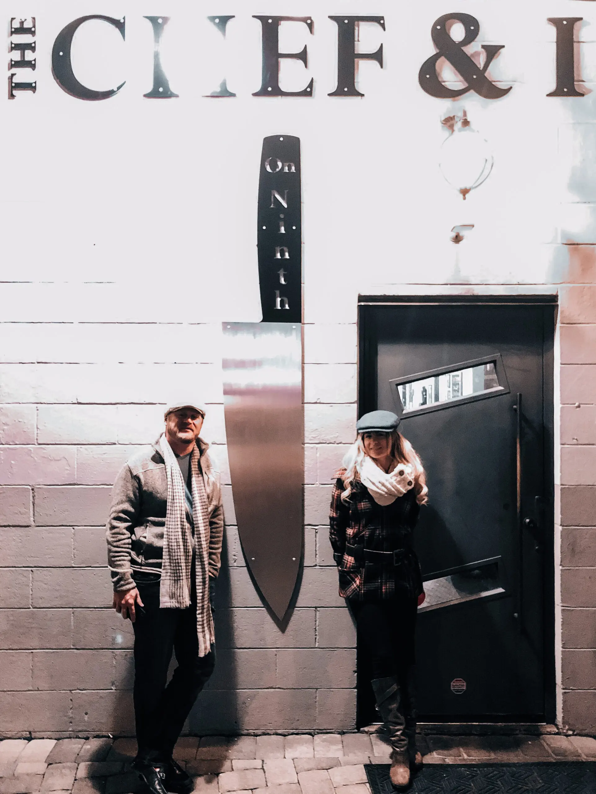 woman with a bob haircut holding a camera up to her face with a light in the background