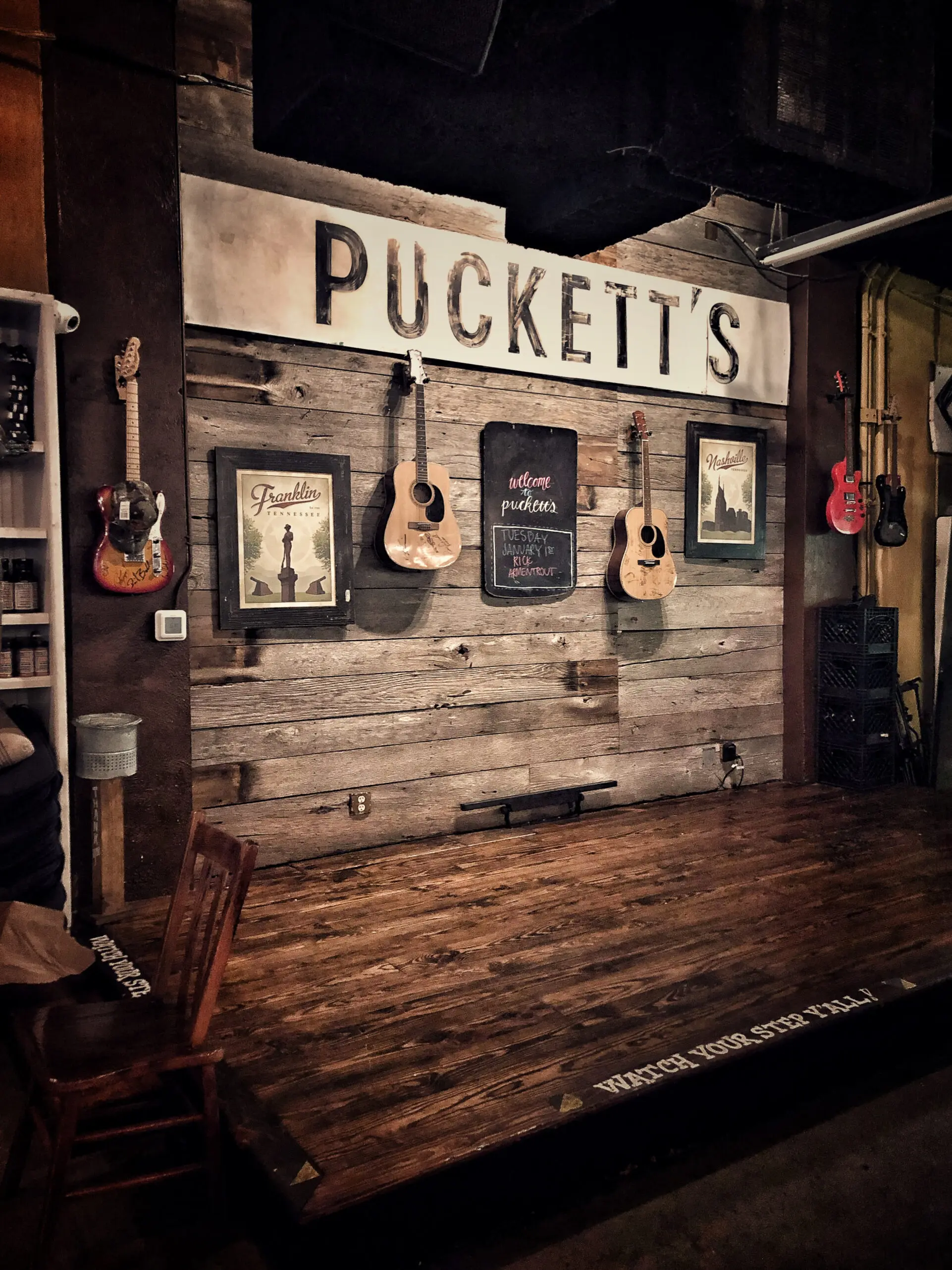 woman with a bob haircut holding a camera up to her face with a light in the background