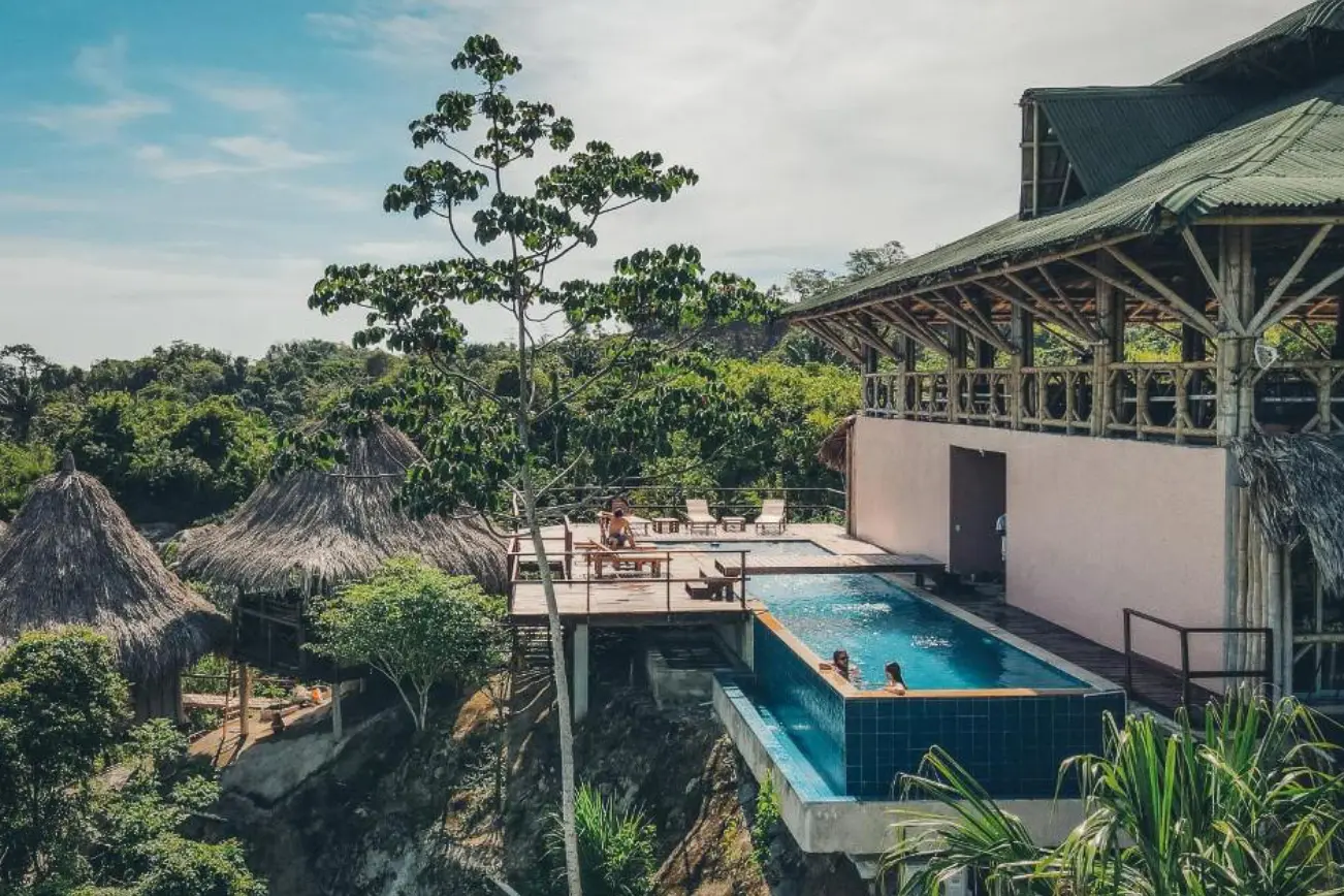 woman with a bob haircut holding a camera up to her face with a light in the background