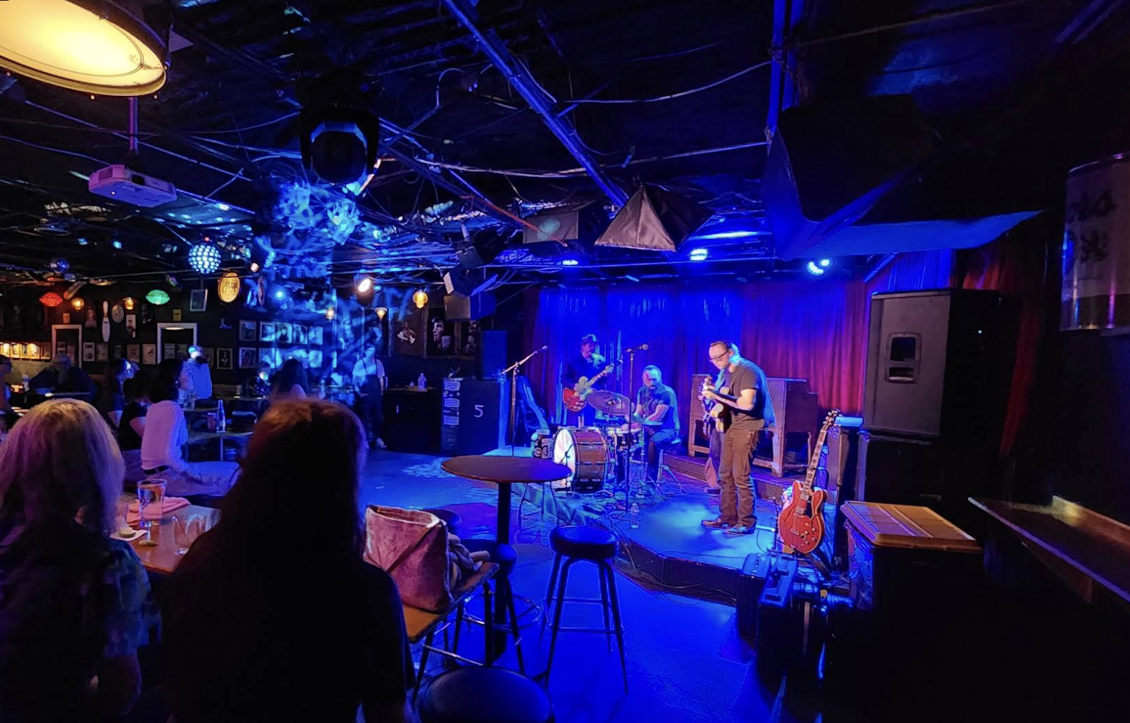 woman with a bob haircut holding a camera up to her face with a light in the background
